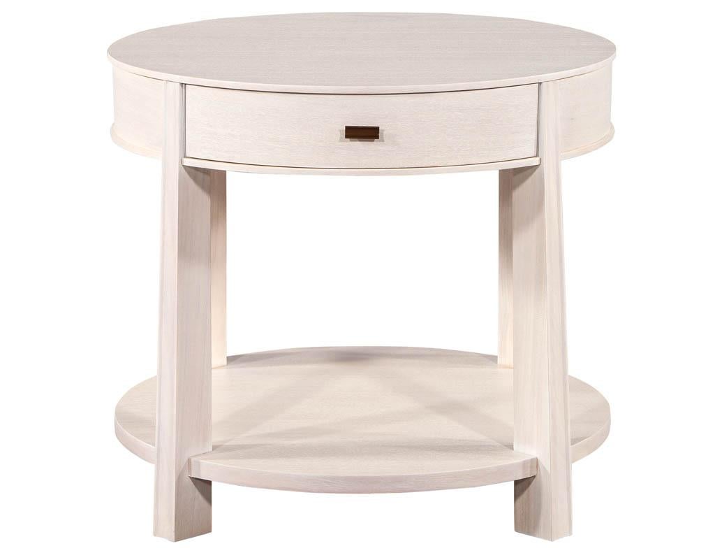 Pair of Round Bleached Side Tables by Barbara Barry. Acid washed mahogany top with single storage drawer. Featuring unique natural washed finish, sleek metal hardware with bottom tier storage area.

Price includes complimentary curb side delivery