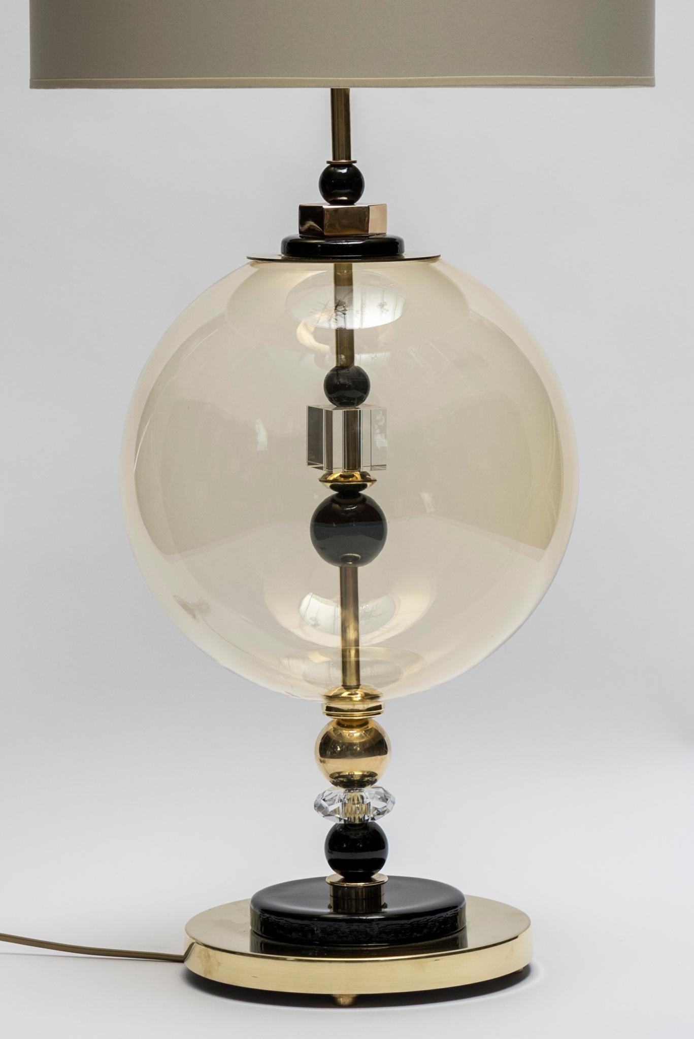 Pair of table lamps made of brass with black Murano glass pieces and a large globe as a centrepiece.