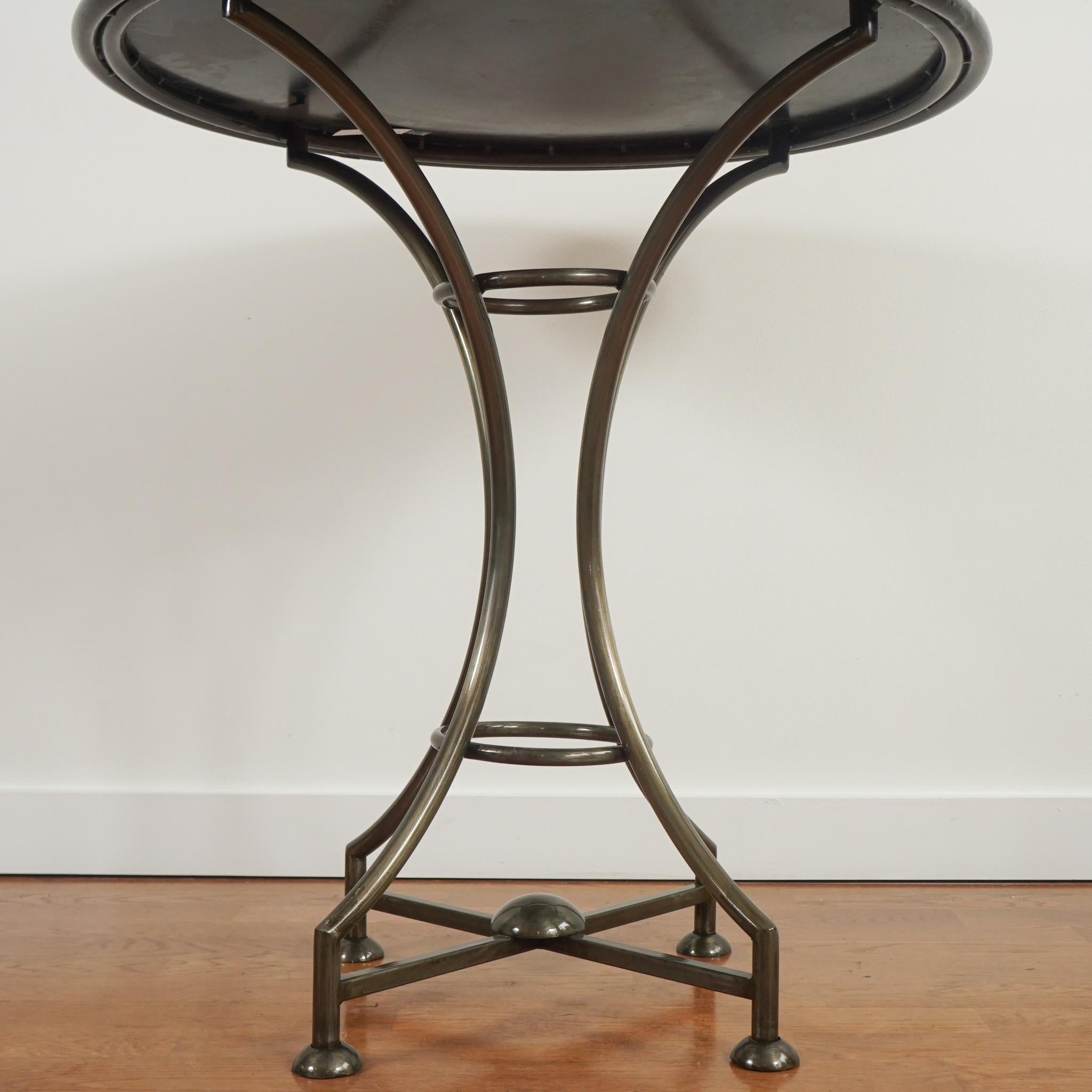 The pair of vintage French gueridon-style iron pedestal base tables, shown here, are distinguished by their faux tortoise ringed surface finish.  Sized for use as end tables or occasional tables, the tables are in very good condition and ready to