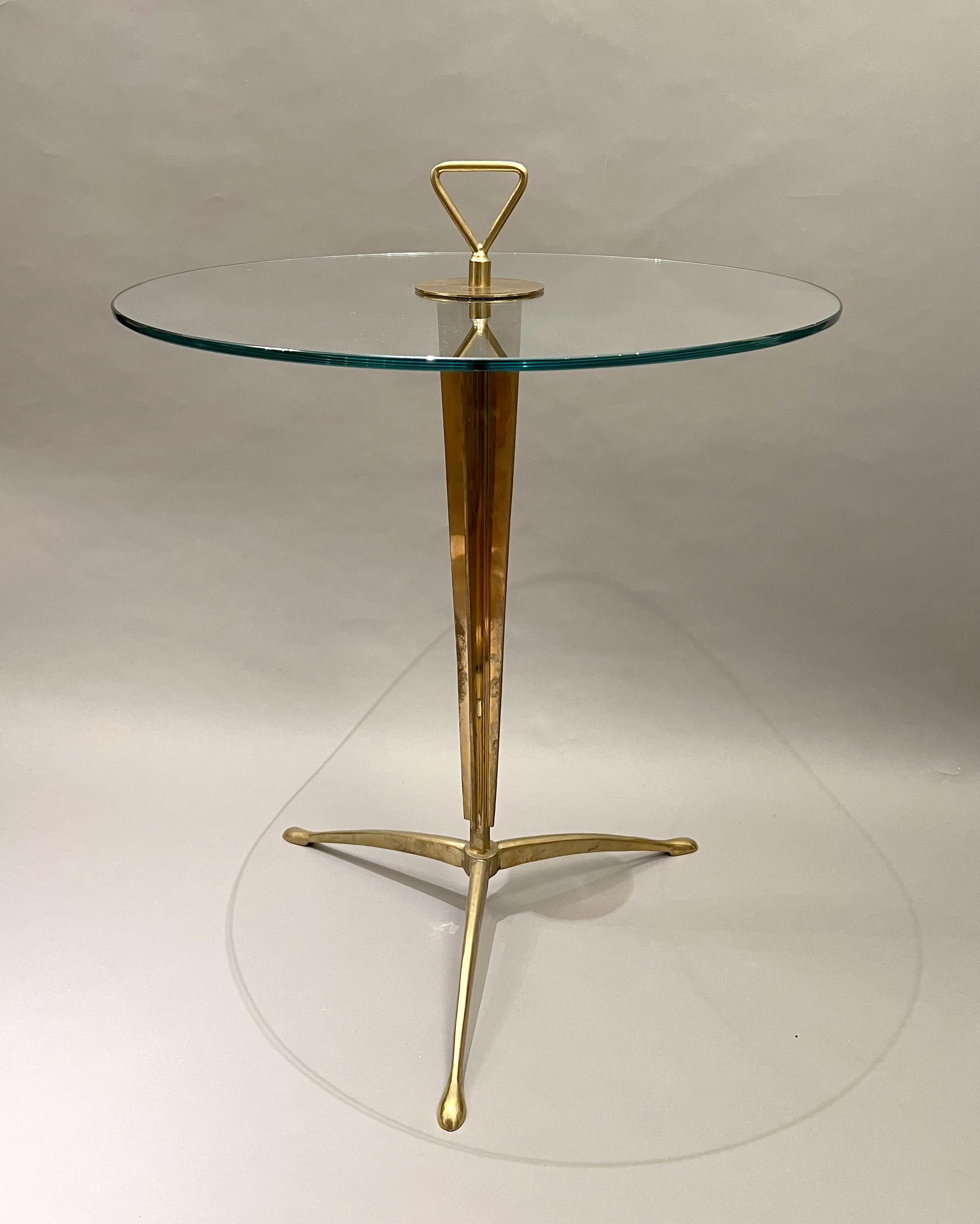 Pair of pedestal tables in solid brass and glass. Central finned shaft resting on a tripod base. They are fitted with a handle for easy moving.
Diameter: 55 cm (21,6 inches)
Height: 61 cm (24 inches)
Height with handle: 70 cm (27,5 inches)