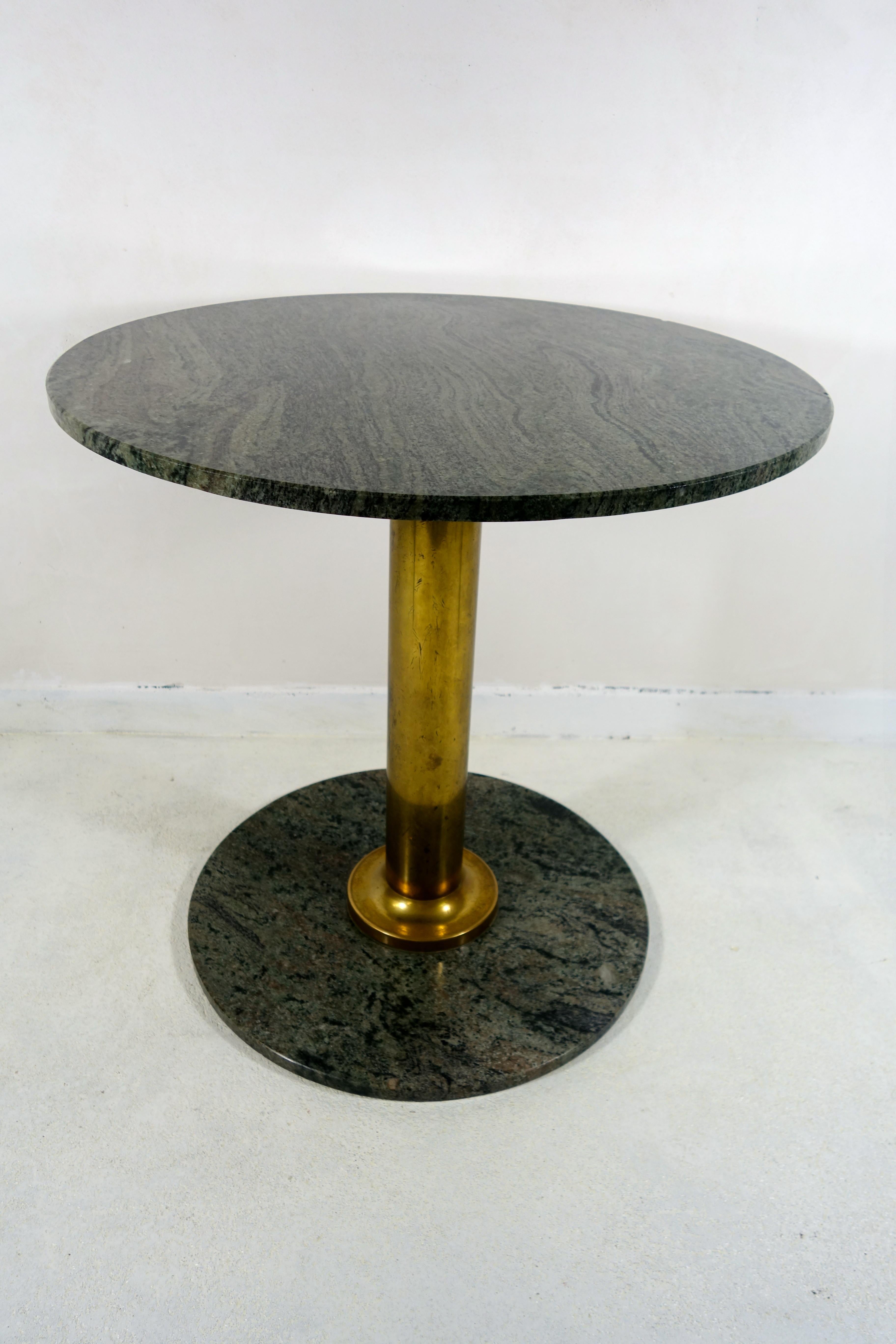 Two elegant and very heavy round tables with green granite tops and feet and brass leg.
They originate from the French restaurant Le Parc of a five star hotel in Frankfurt am Main, a restaurant that was well known for its refined kitchen and French