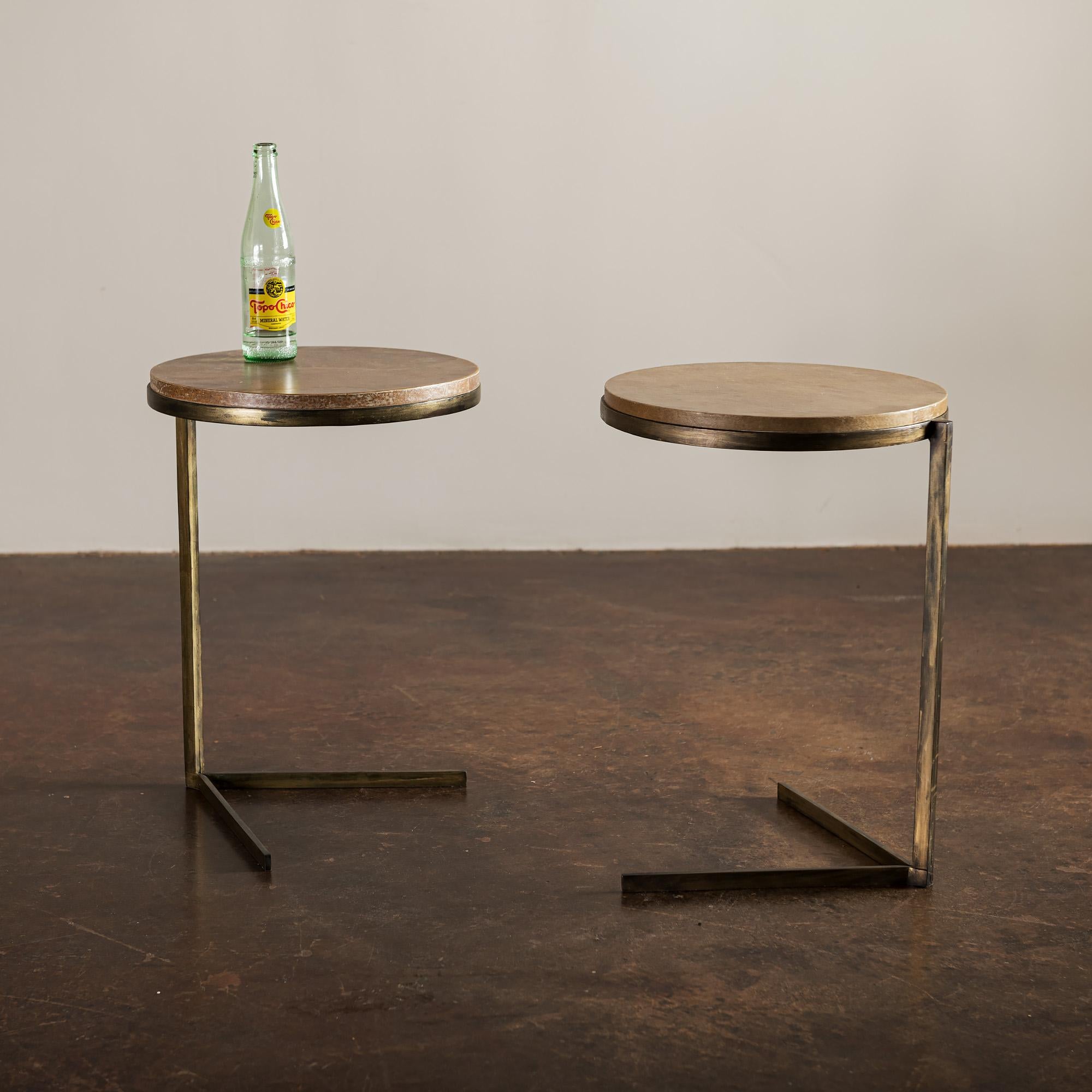 A pair of elegant round iron side tables with cantilevered parchment tops, France, 1950s.
