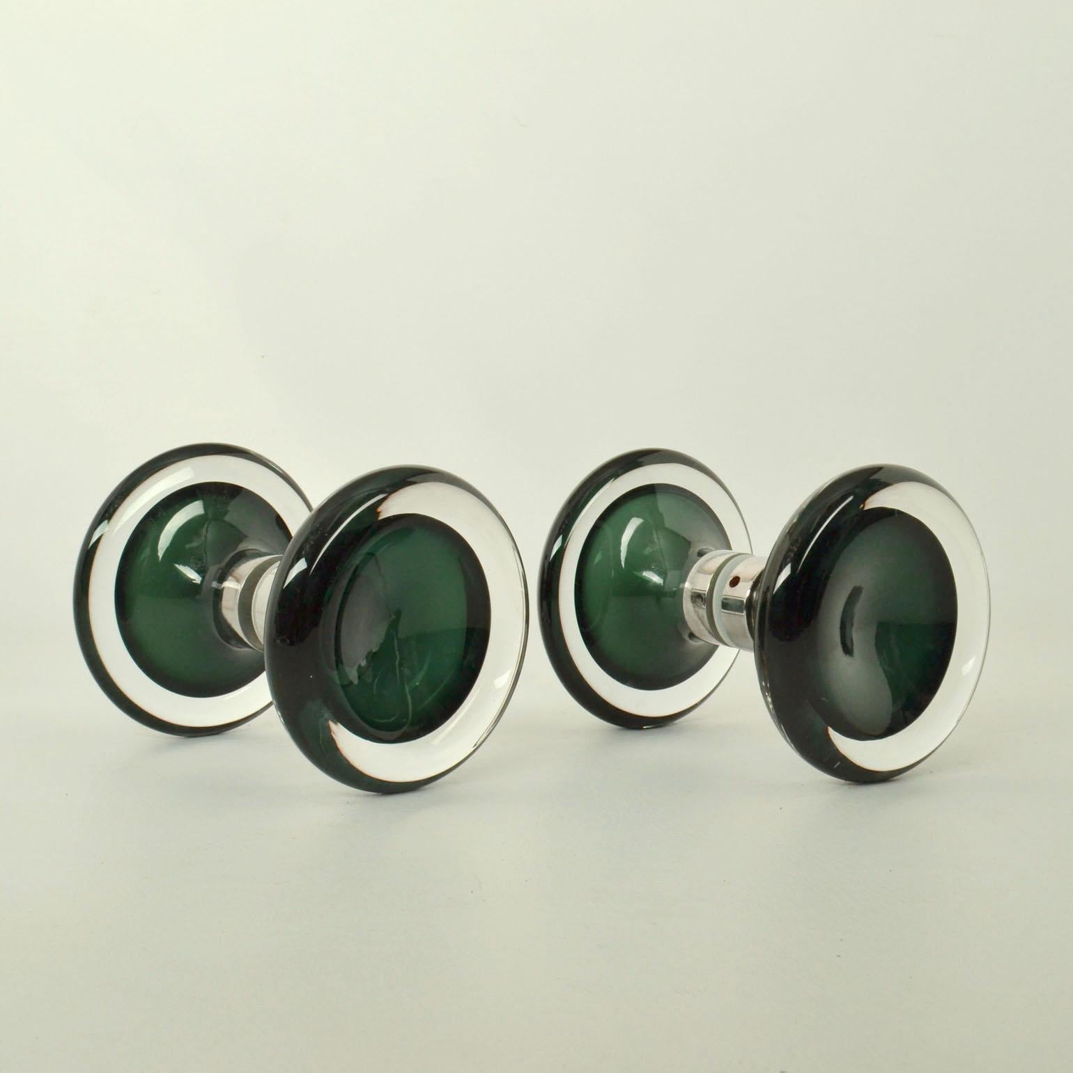 Two round double door handles in solid glass hand blown Sommerso Murano glass with center in emerald green and outer ring in clear glass with chrome fittings.
Sommerso is an Italian glass technique used in producing the handles to create several