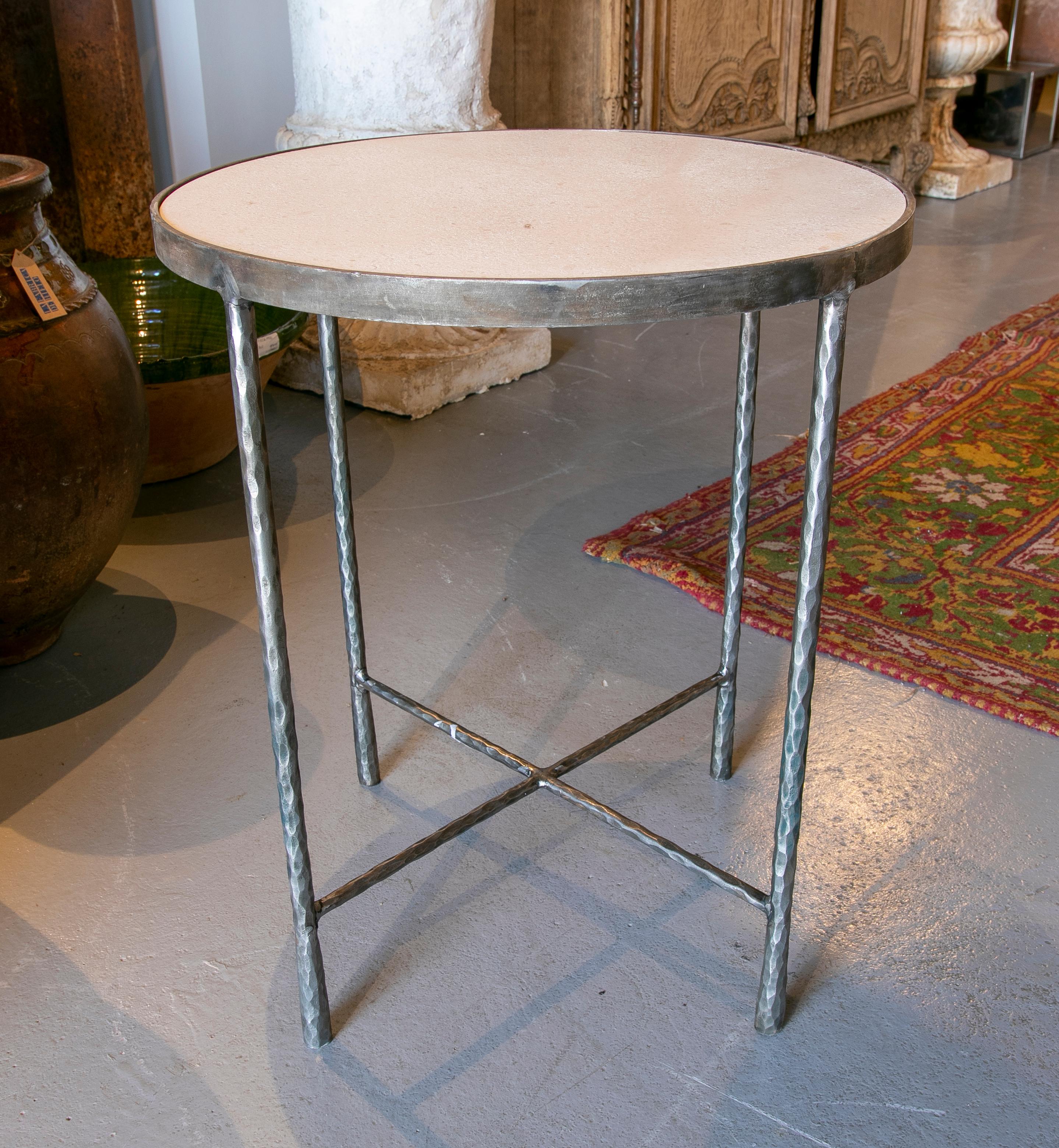 Pair of round side tables in forged iron and limestone marble tops.