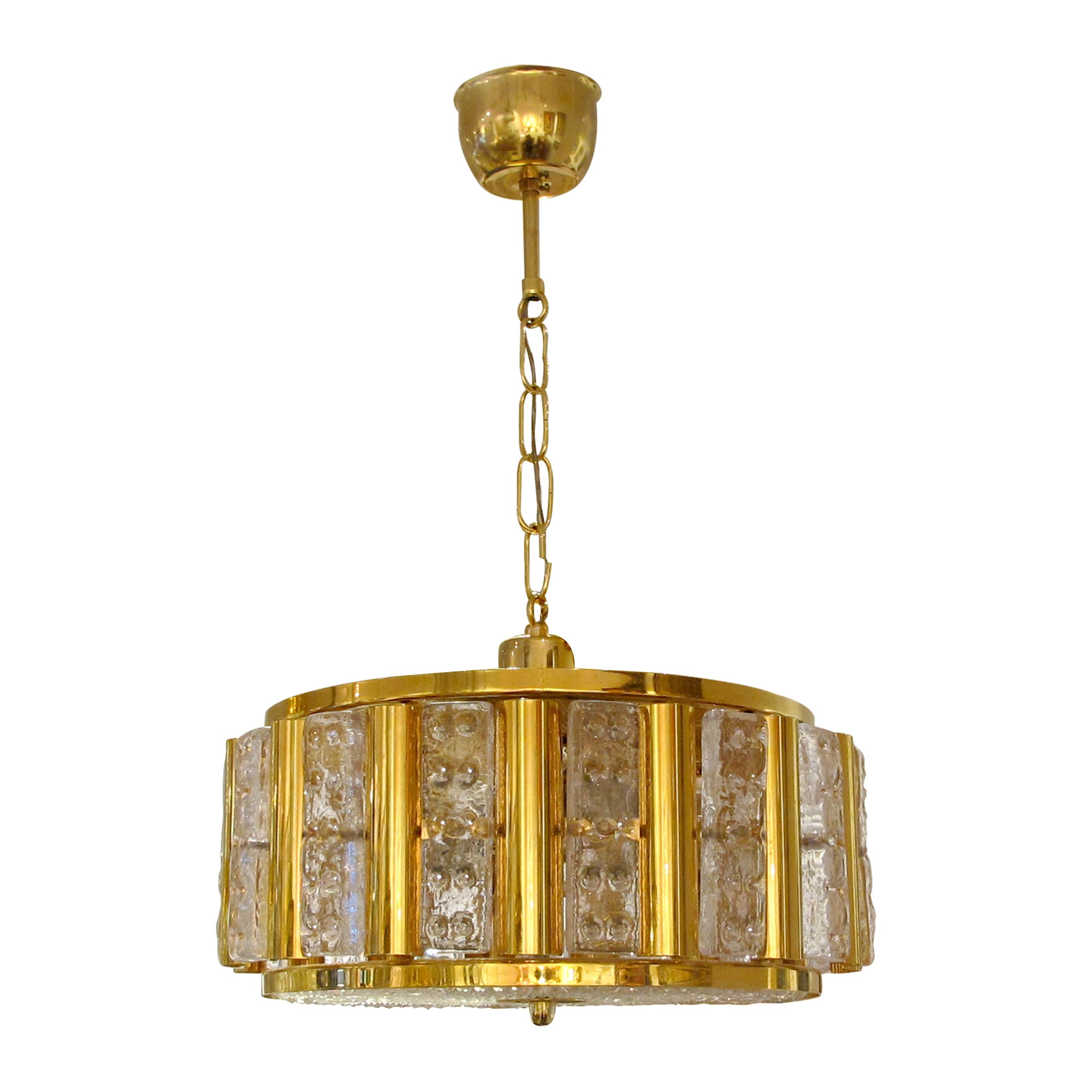 Pair of 1960s glass and polished brass ceiling hanging lights designed by Carl Fagerlund and manufactured by Orrefors in Sweden. These elegant lights are in great condition and offer warm lighting ideal for over a counter side by side. The lights