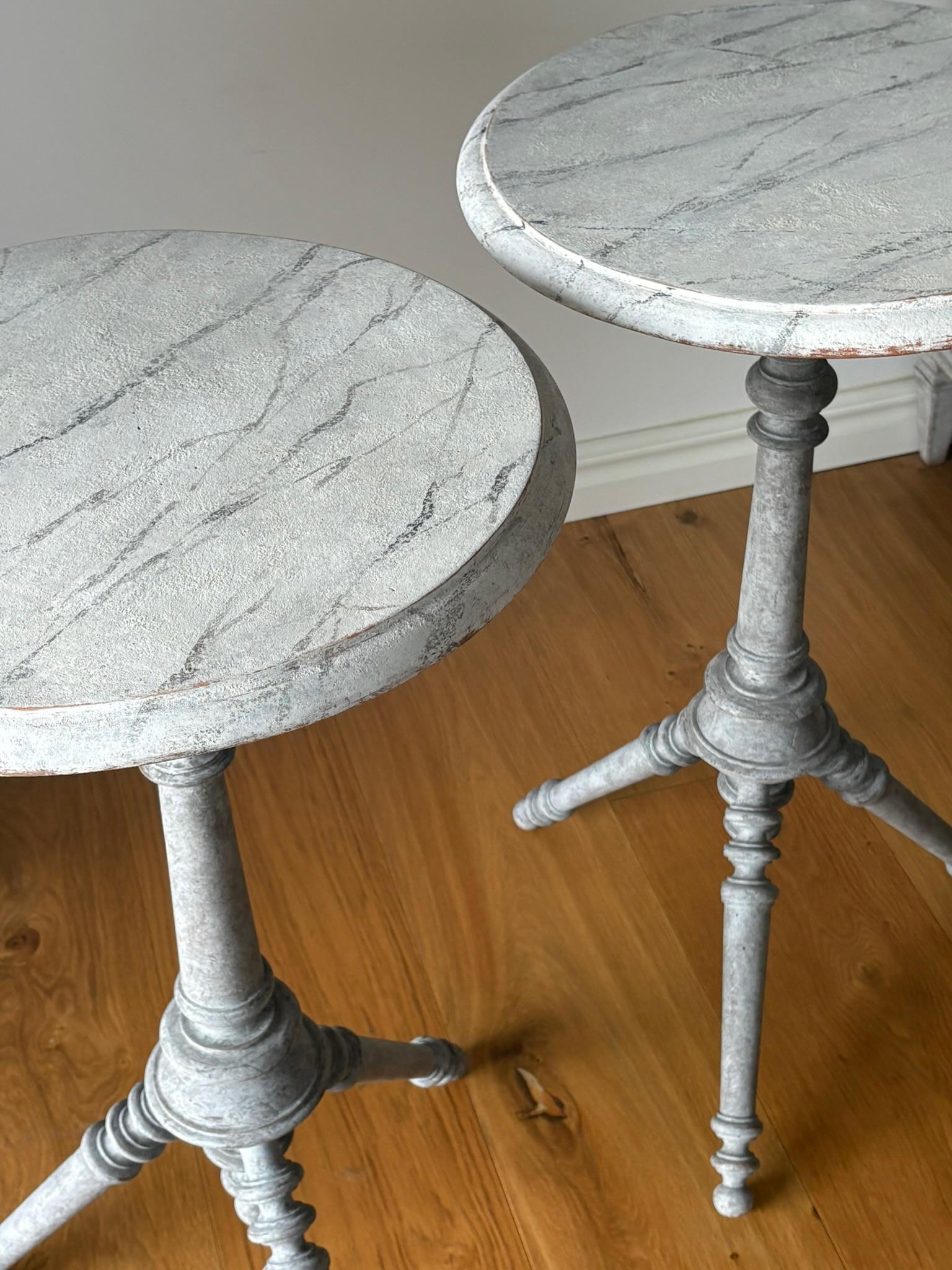 Pair of Swedish 19th Century pedistal tables. These wonderful tables have decorative tripod bases. Both have round tops with slightly scalloped edges! 
They have been re-painted with a typical light grey, paint that highlights their decorative