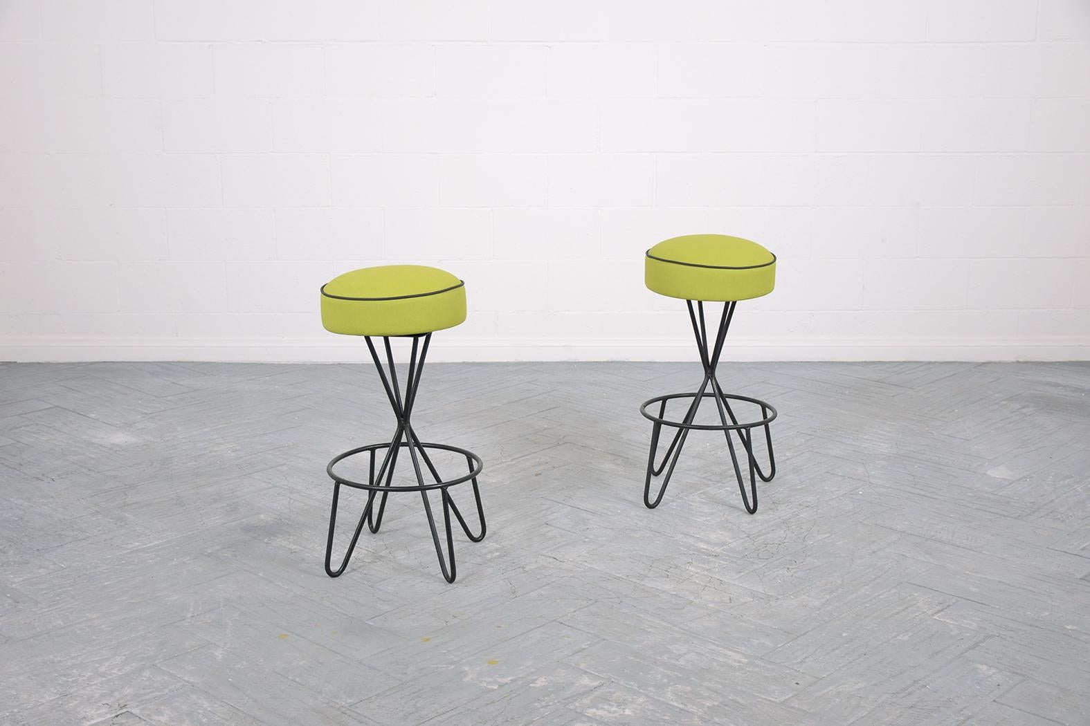 Introducing our expertly restored Mid-Century Modern Swivel Bar Stools, a perfect blend of vintage charm and contemporary design. In pristine condition, these stools boast a sturdy wrought iron base, freshly painted in a sophisticated black finish.