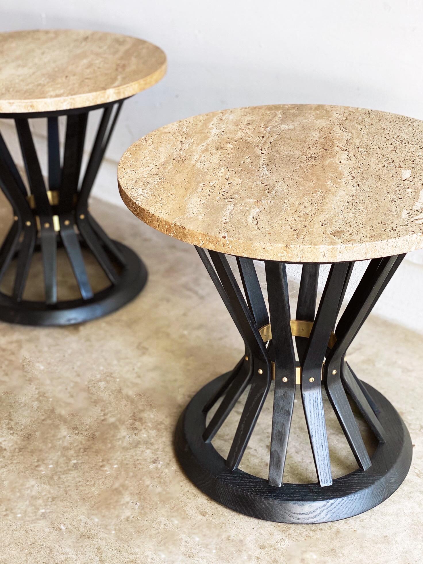 This pair of round travertine 'Sheaf of Wheat' tables by Edward Wormley for Dunbar Furniture Corporation are in overall great condition. An intricate pair, fully restored ebonized ash frames, brass details, and original travertine tops. Brass Dunbar