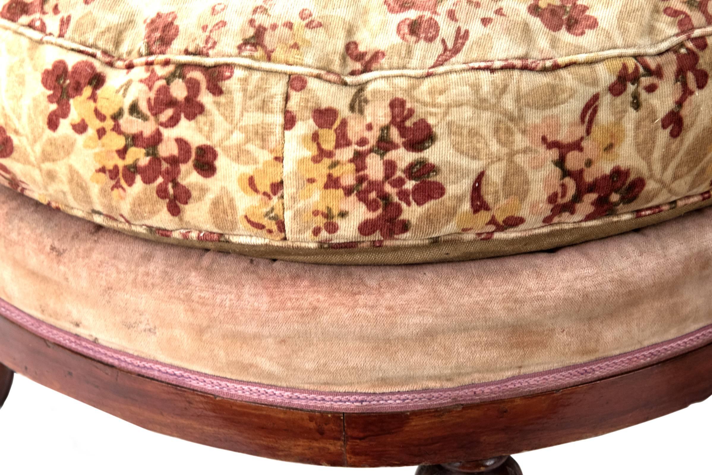 A pair of round stools with an upholstered cushion on an older upholstered and trimmed round wooden base with four tapering and fluted legs. Measures: 14 x 23 inches.