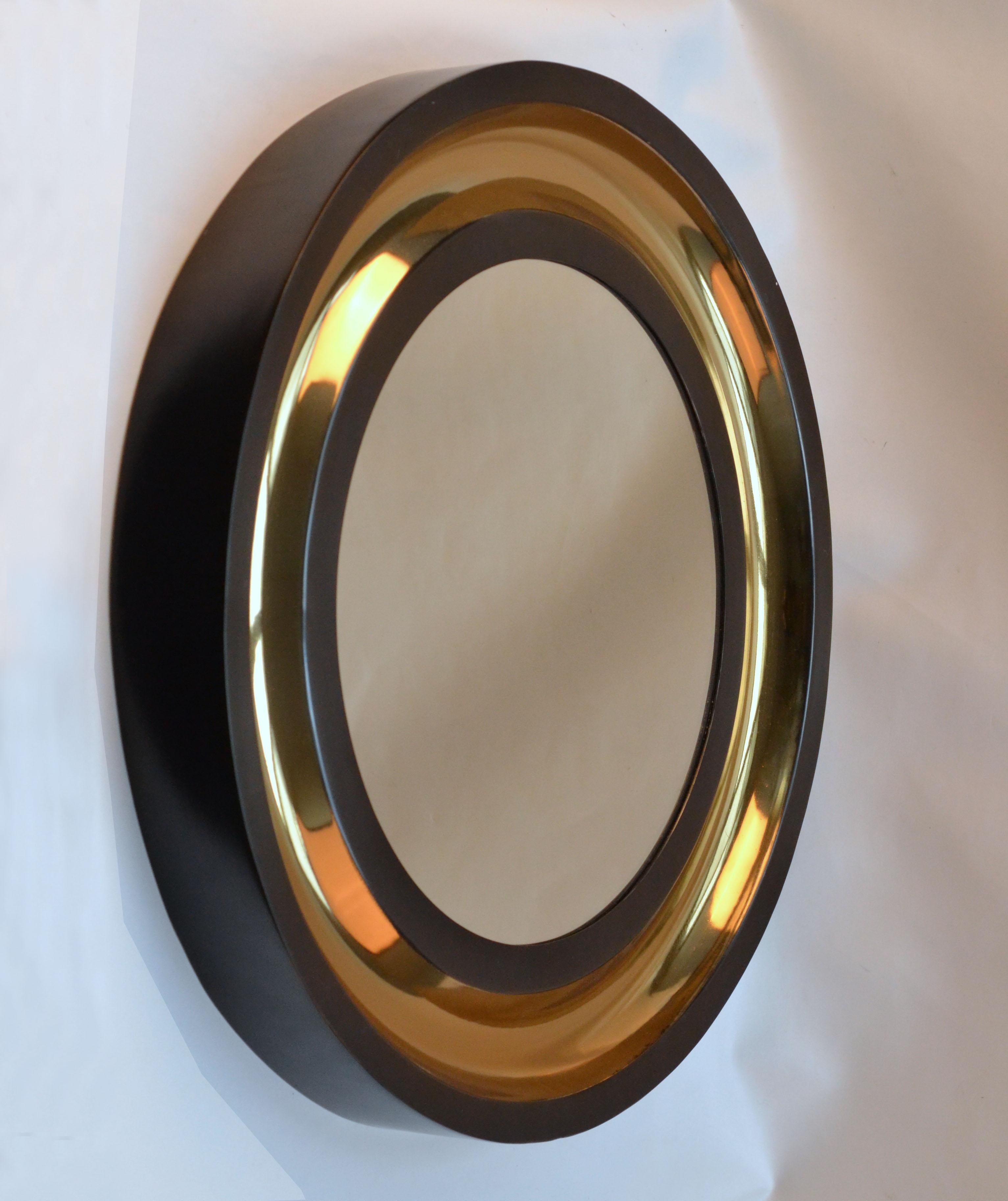 Two extruded round mirrors edged with a generous border forming a continuous, indefinite concave profile. The metal frame of the mirror is then patinated in bronze and metallic sateen black emphasizing on an excellent surface finish. The roundness