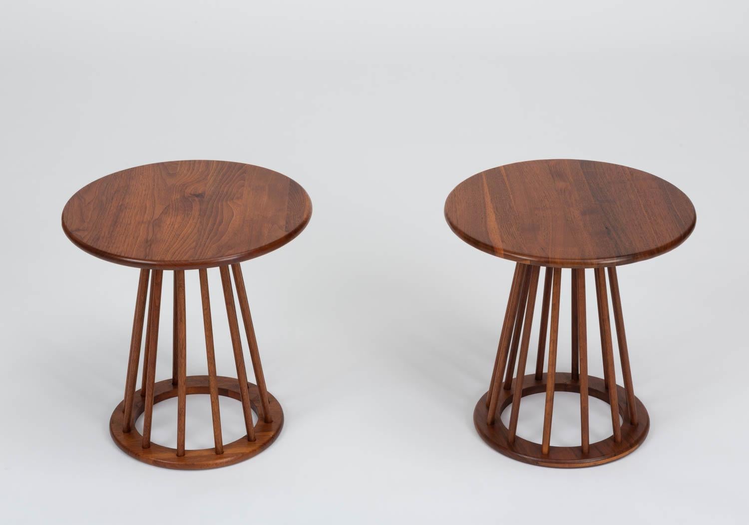 A pair of simply constructed side tables from the late 1950s by Arthur Umanoff for New Jersey-based Washington Woodcraft. The tables feature a round, bull-nosed surface of solid walnut supported by a pedestal base, a smaller ring in matching walnut