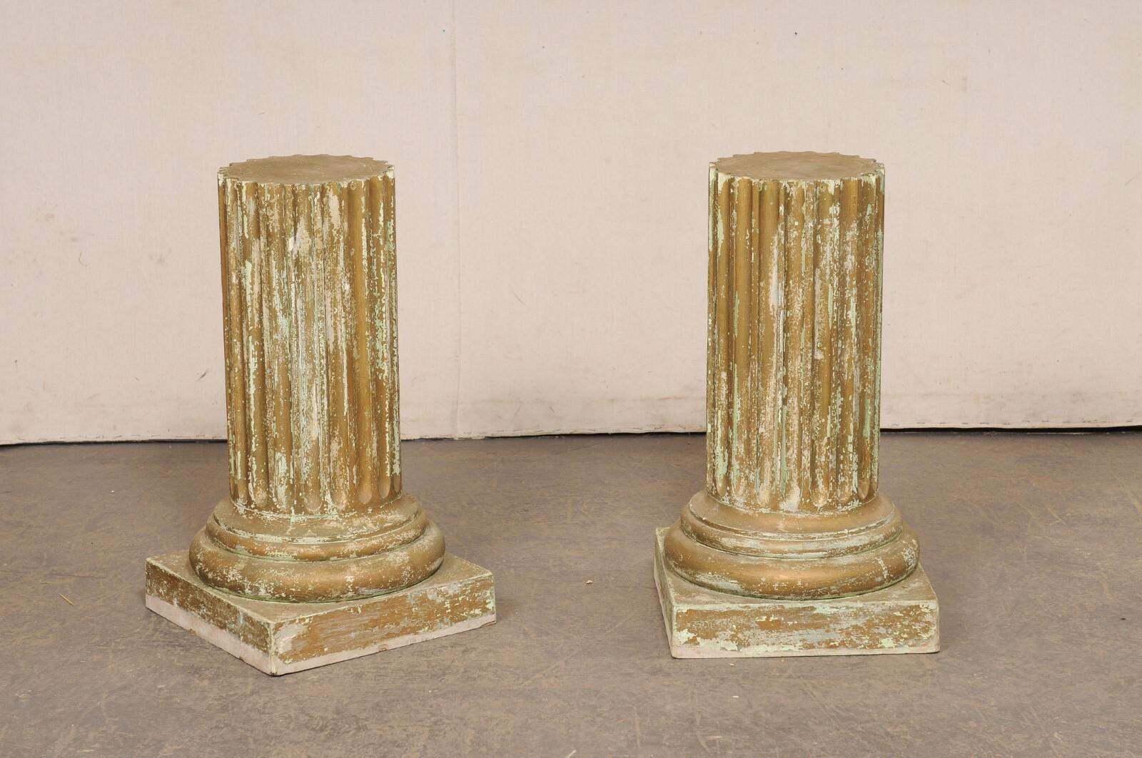Paire de colonnes en bois peint d'époque. Ces piédestaux présentent tous des corps arrondis avec des détails cannelés, les parties inférieures étant enveloppées d'une série de moulures arrondies et reposant sur des bases de piédestal de forme