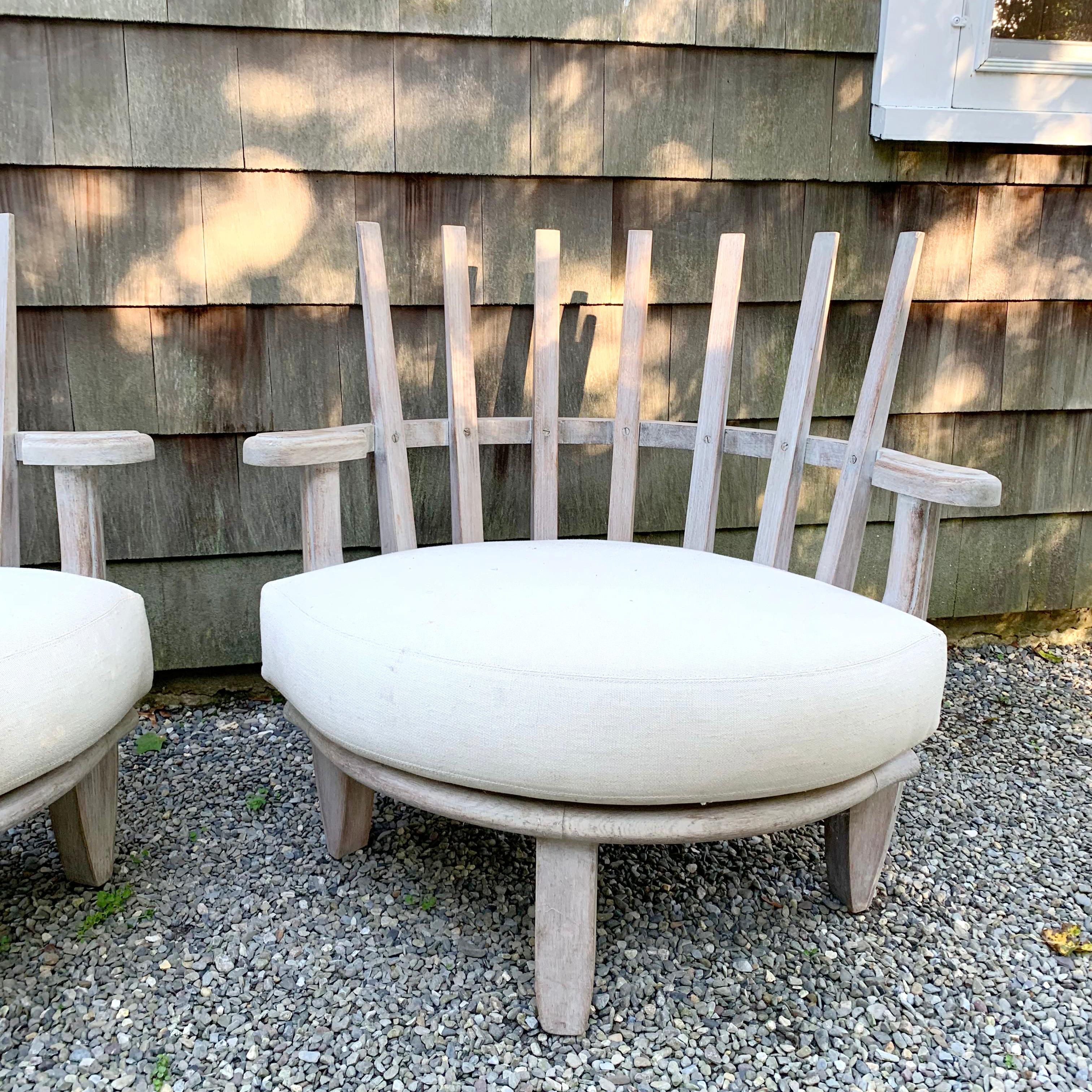 Pair of sculptural solid wood rounded slat-back chairs in the style of Guillerme & Chambron. Carved accent detail on arms and legs. Thick upholstered seat cushion. Curved leg and arm detailing. 