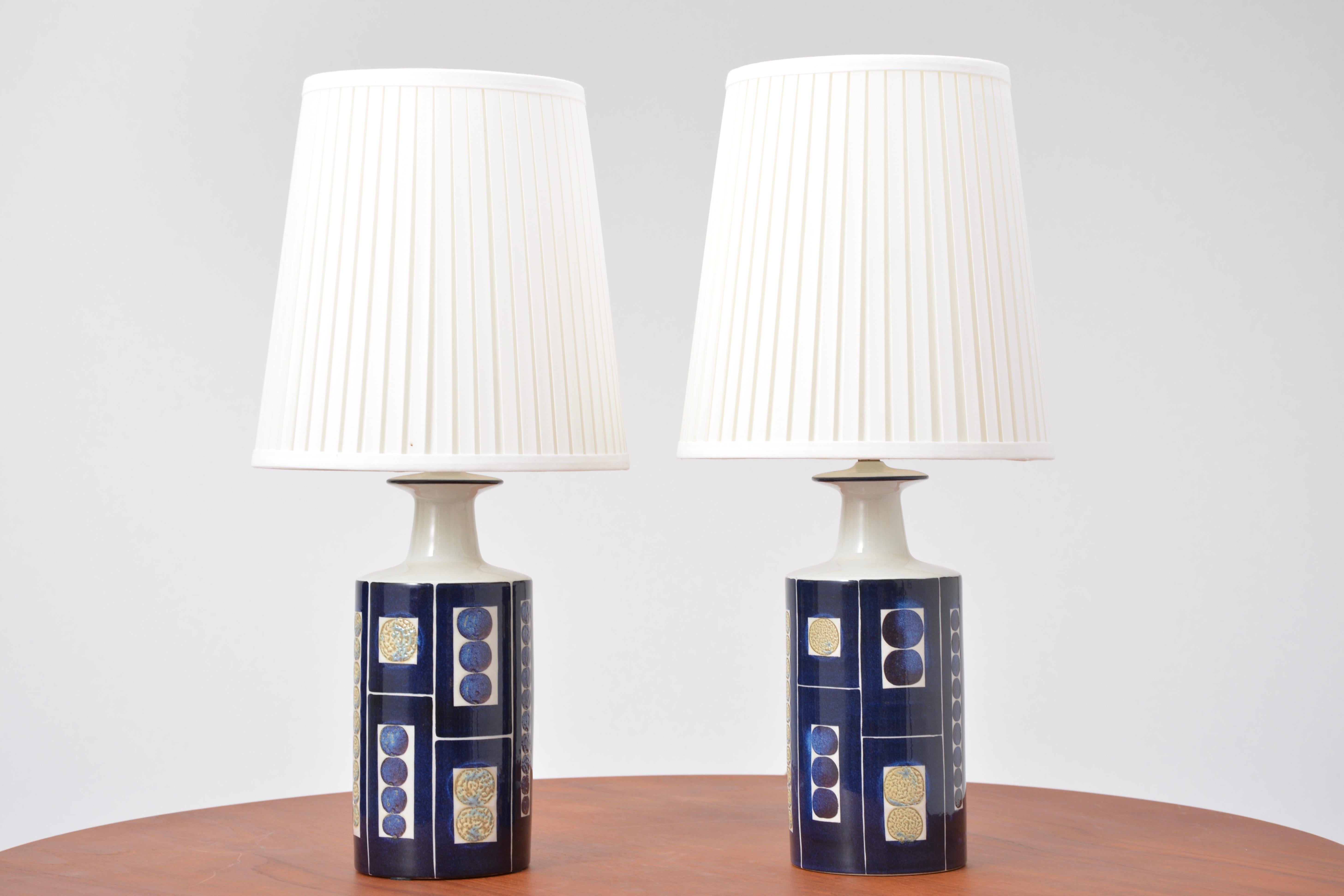 Pair of decorative table lamps from aluminia/Royal Copenhagen and Fog & Mørup. The lamps were produced in collaboration with the Danish lamp manufacturer Fog & Mørup. Model no. E 7169
The bold design is by Inge-Lise Koefoed. 
Marked on the bottom