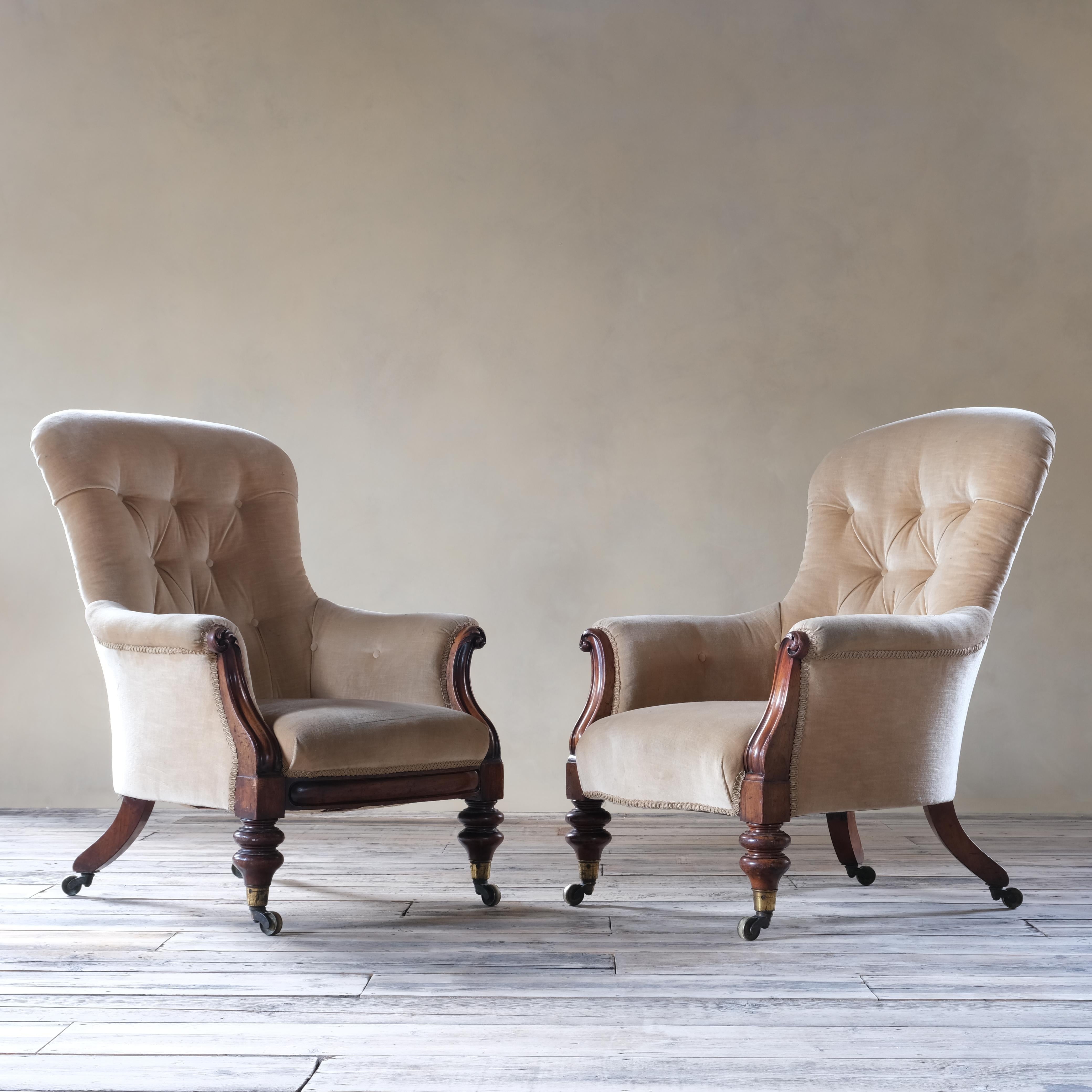 A special pair of well drawn armchairs by Johnstone and Jeanes bearing the Royal VR 'Victoria Regina' stamp. Raised on turned walnut front legs with out splayed legs to the rear and all with the original large Cope & Collinson brass casters. Each