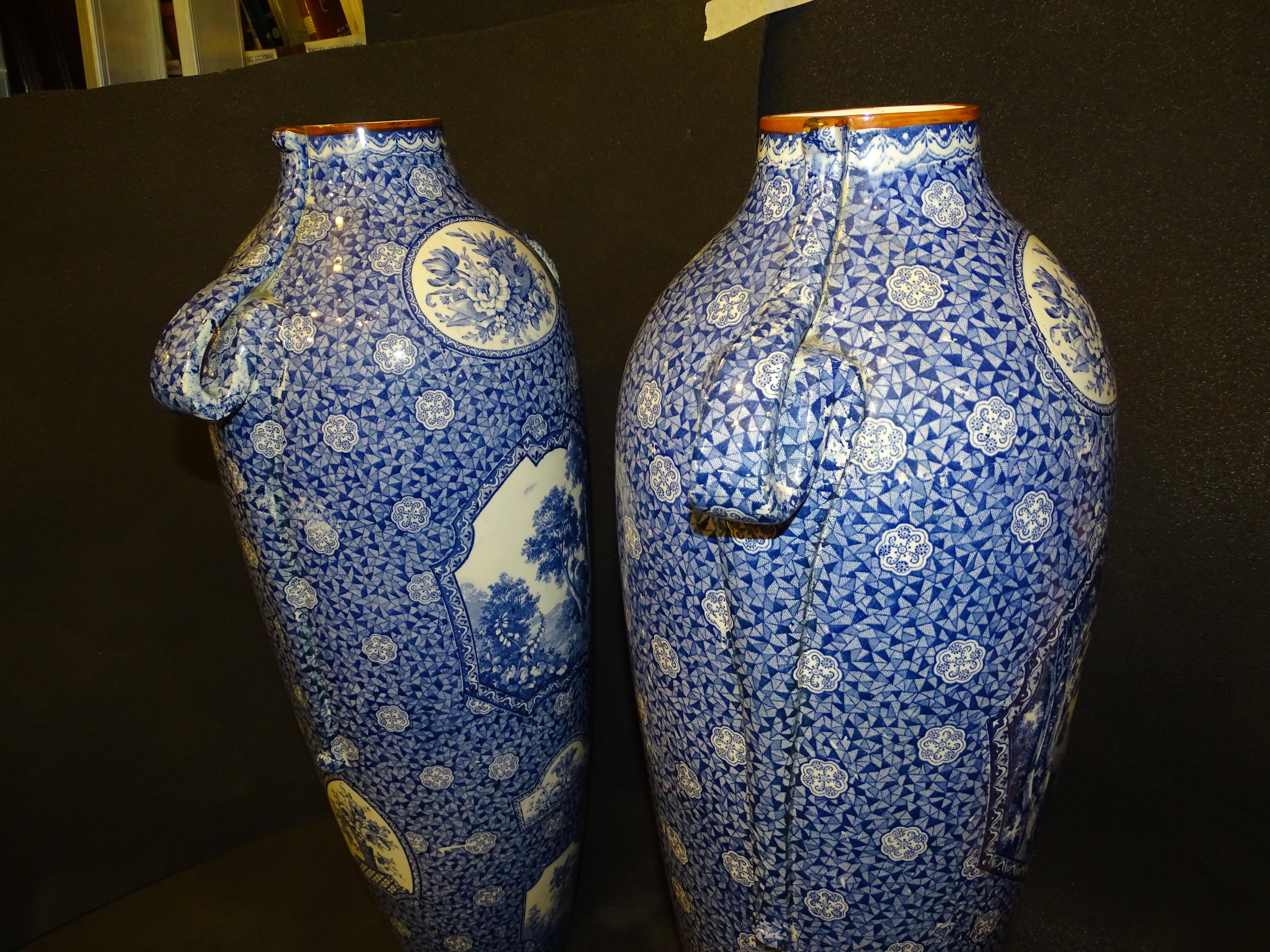 A pair of amazing large ceramic vases in white and blue, “Flamand” style decoration with floral scenes and landscapes with side handles. They have the number 2983 stamped on the base along with the house seal. They are in perfect condition with age