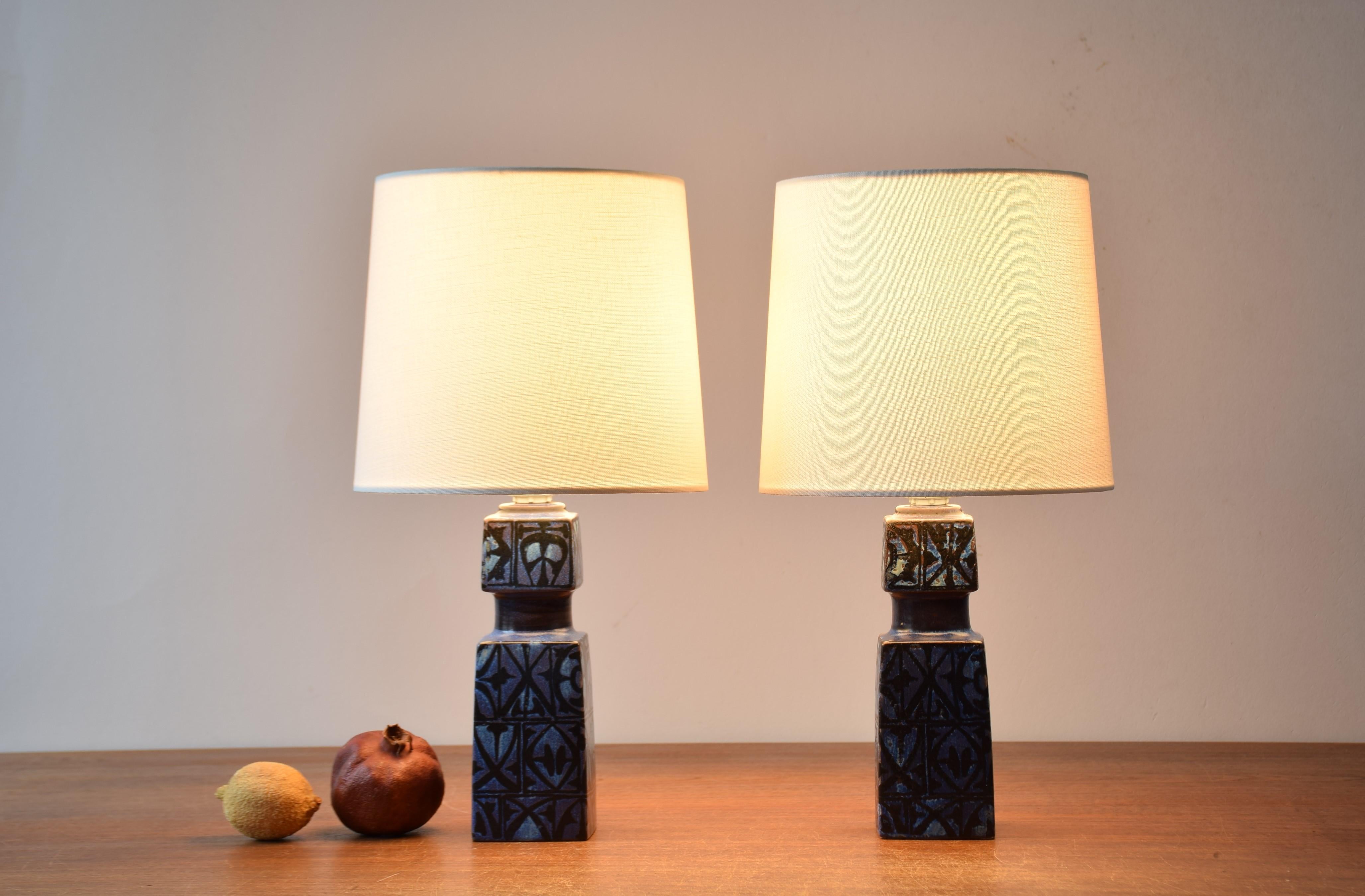 Pair of table lamps designed by Nils Thorsson for Royal Copenhagen and Fog & Mørup and made circa 1970s.
They have a tactile abstract decor with black on dark blue.

Included is a set of new lampshades designed and made in Denmark. They are made