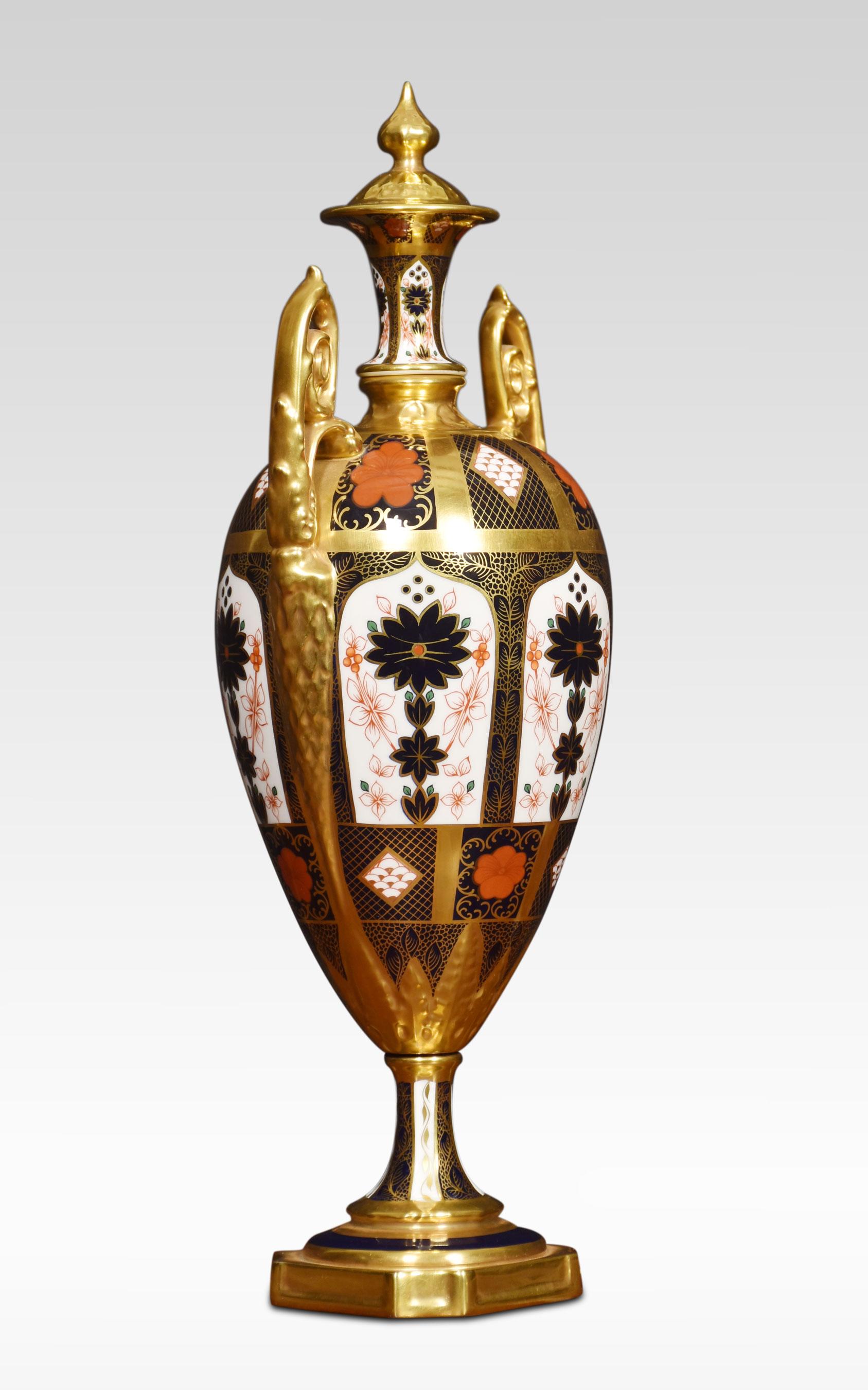 Royal Crown Derby sehr handbemaltes Paar Imari-Porzellan-Doppelgriffvasen in Form einer Urne mit hohem Deckel, mit 22 Karat Goldbändern. Erhöht auf achteckigen Sockeln. (eine Vase hat einen leichten Haarriss im Deckel).
Abmessungen
Höhe 17