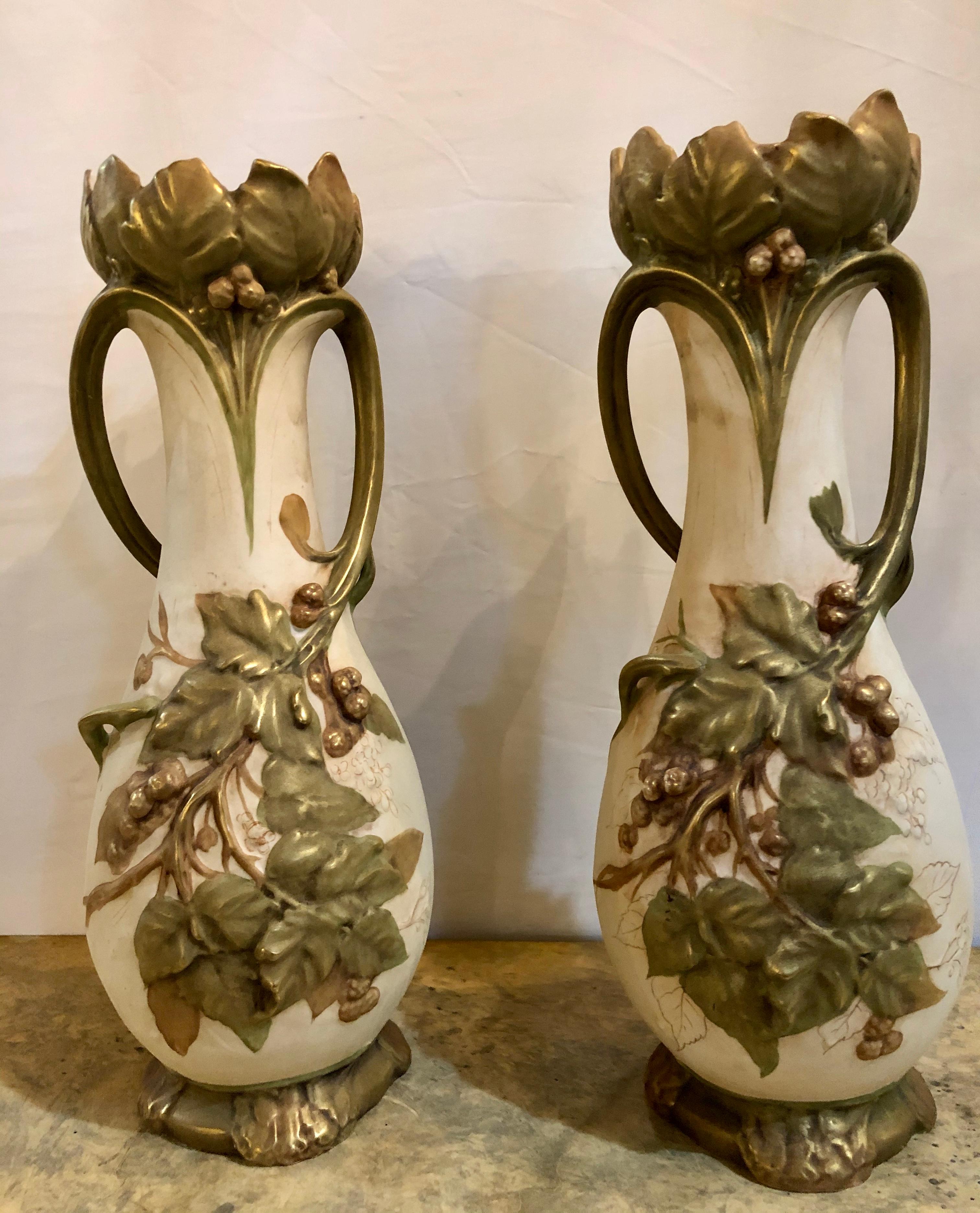 Coppia di vasi da fiori o centrotavola in stile Nouveau Royal Dux. Ciascuna reca il sigillo di Royal Dux e il numero di inventario sul retro. Una bella coppia di vasi in porcellana, ciascuno dei quali raffigura un grappolo d'uva in rilievo.


ISX.