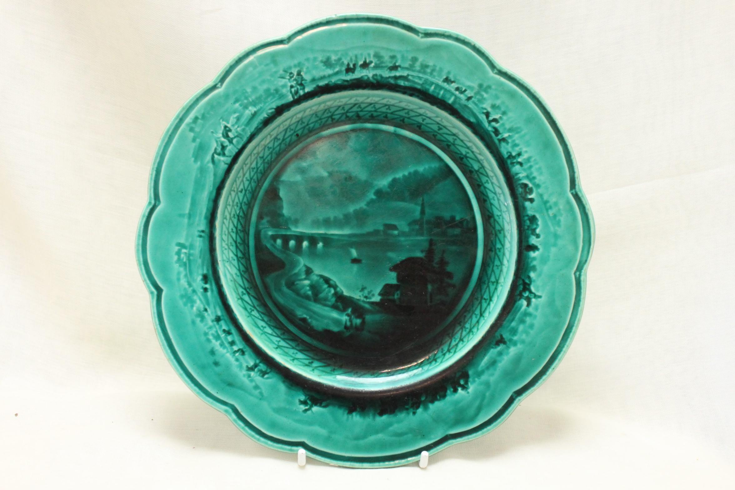 The decoration on this pair of Email Ombrant majolica dessert plates from the Rubelles factory is achieved using graduated intaglio designs that are then flooded with the glaze to give form to the design. In some ways it is similar to the technique