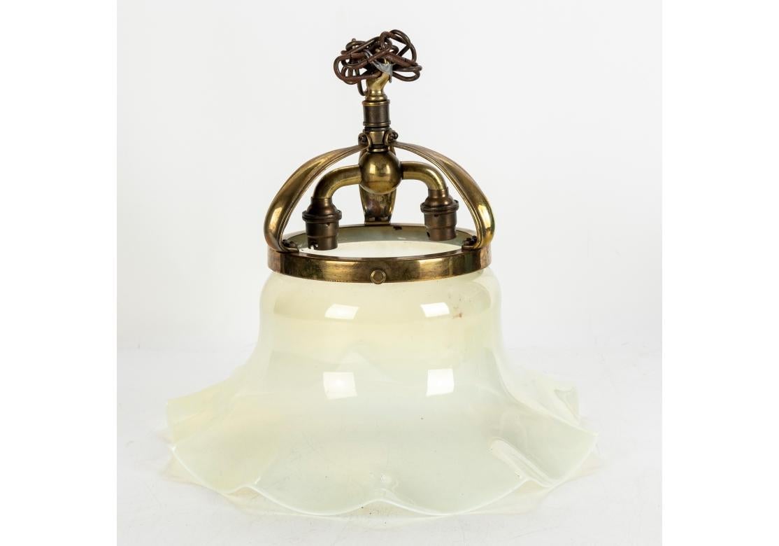 A wonderful design with crown like brass three part top mount with inner mount for the twin lights. Deep ruffled shades in delicate shaded amber to opaline glass. Not wired. Will require electrification. The lamps are set for a push and turn bulb at