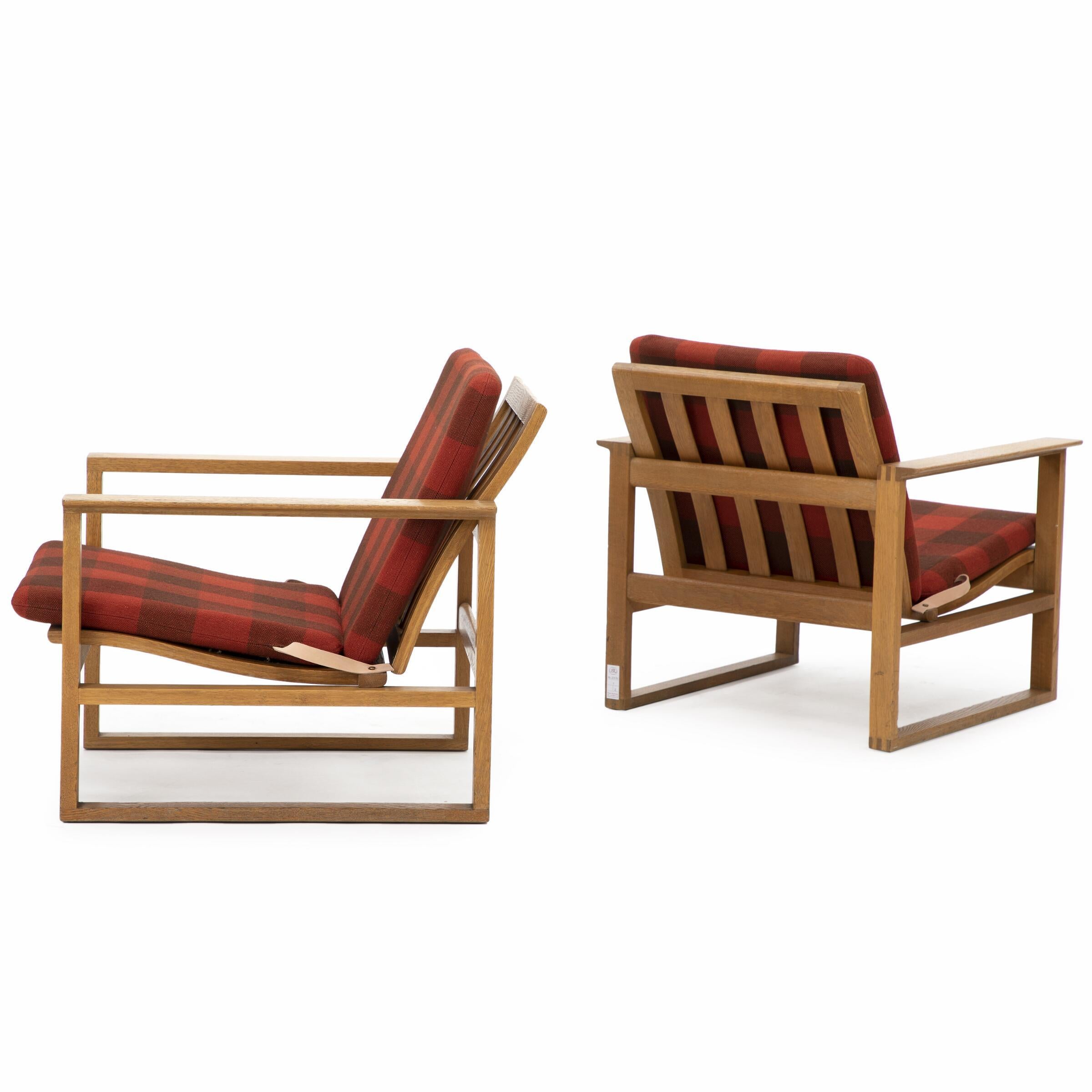 Pair of “Runner Chairs” by Børge Mogensen. 
A pair of easy chairs with oak frame, loose cushions in seat and back upholstered with red checquered wool. Model 2256. Manufactured and marked by Fredericia Stolefabrik.
Dimensions: 26 W 30 D 27 H ;