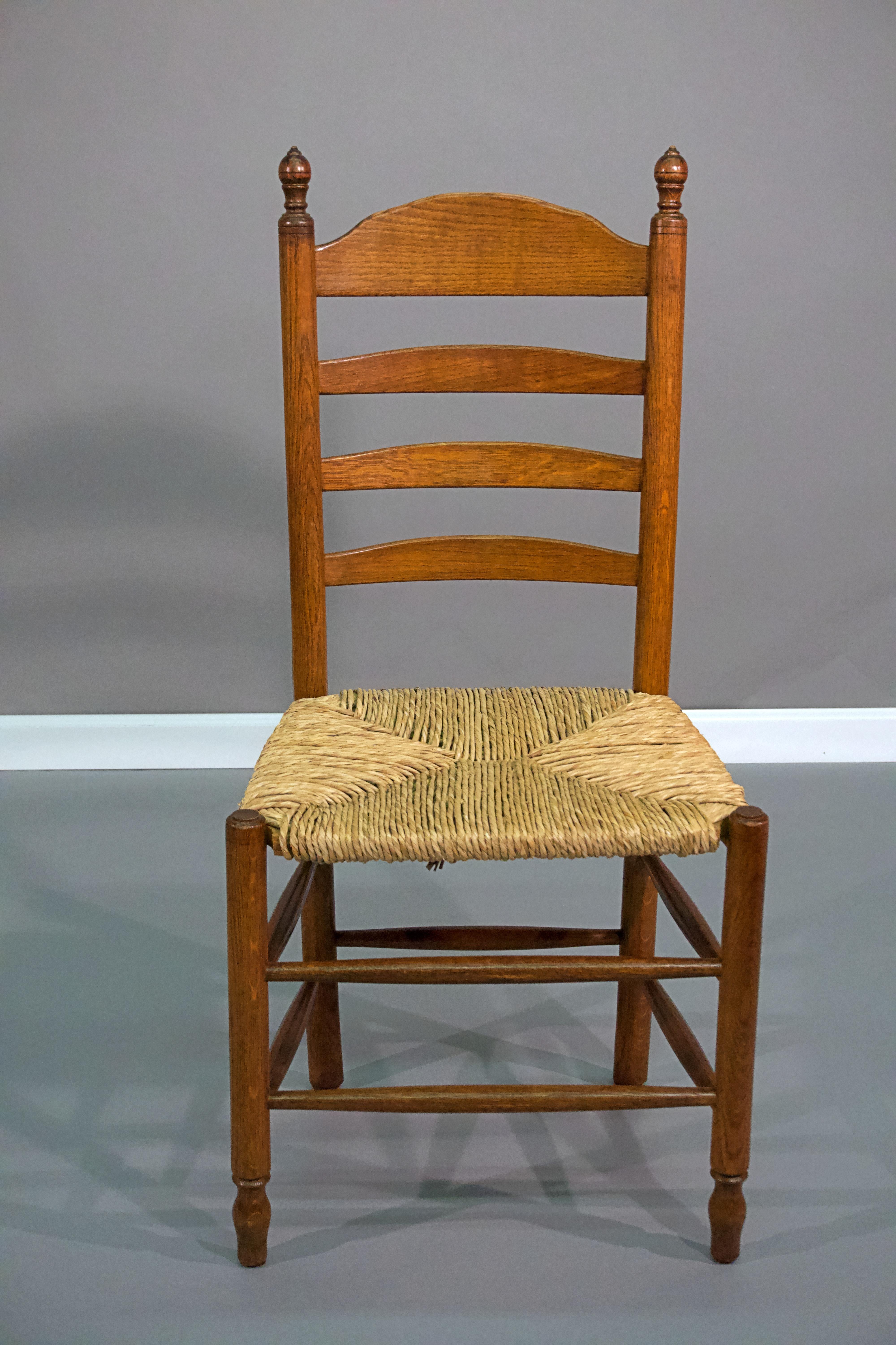 A pair of American rush seat ladder back oak side chairs.