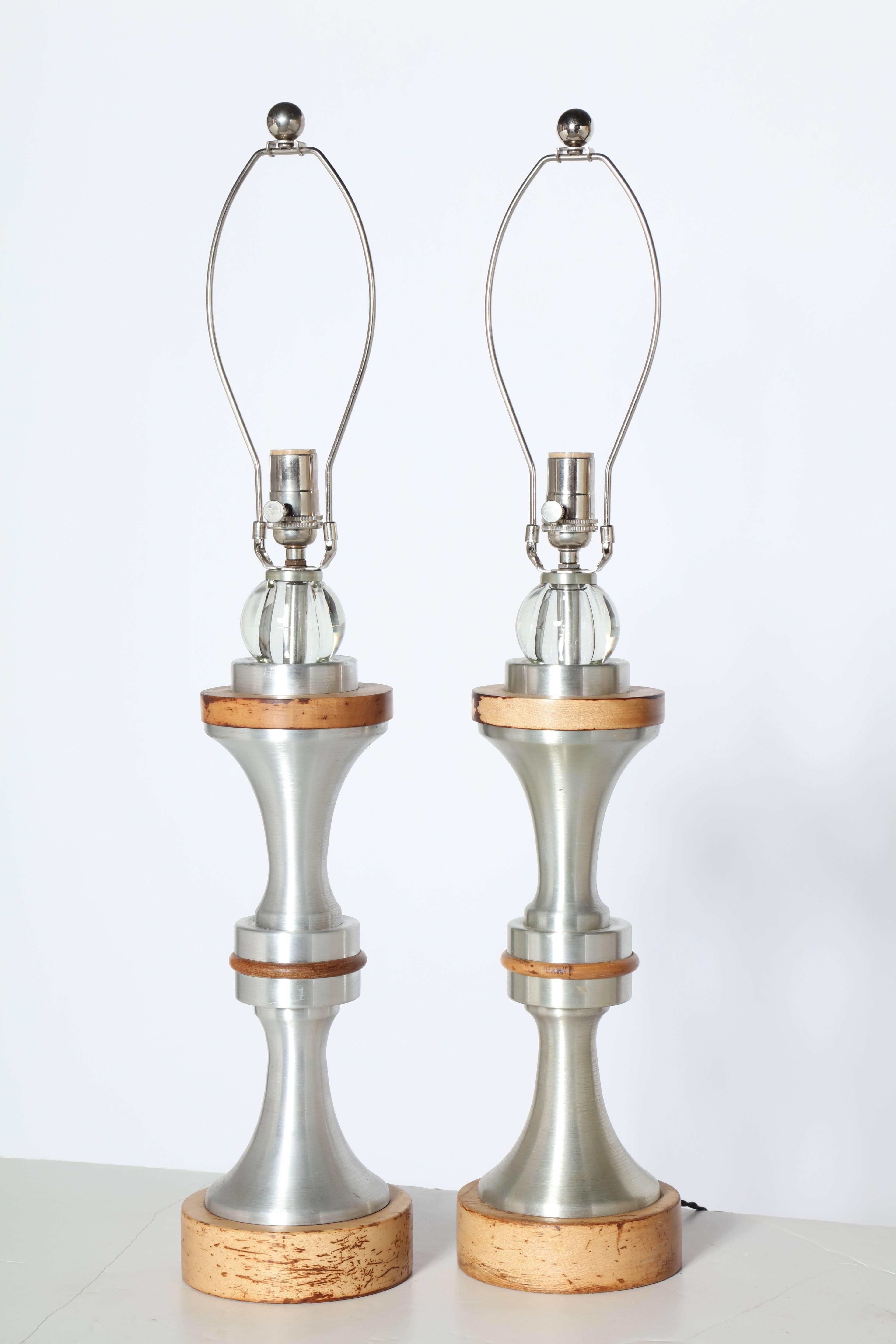 Pair of Mid Century Russel Wright attributed stacked Spun Aluminum, Maple and Crystal Table Lamps. Featuring a machined spun aluminum hourglass form, Maple banded details on circular maple (2H x 6D) base capped with clear crystal balls.