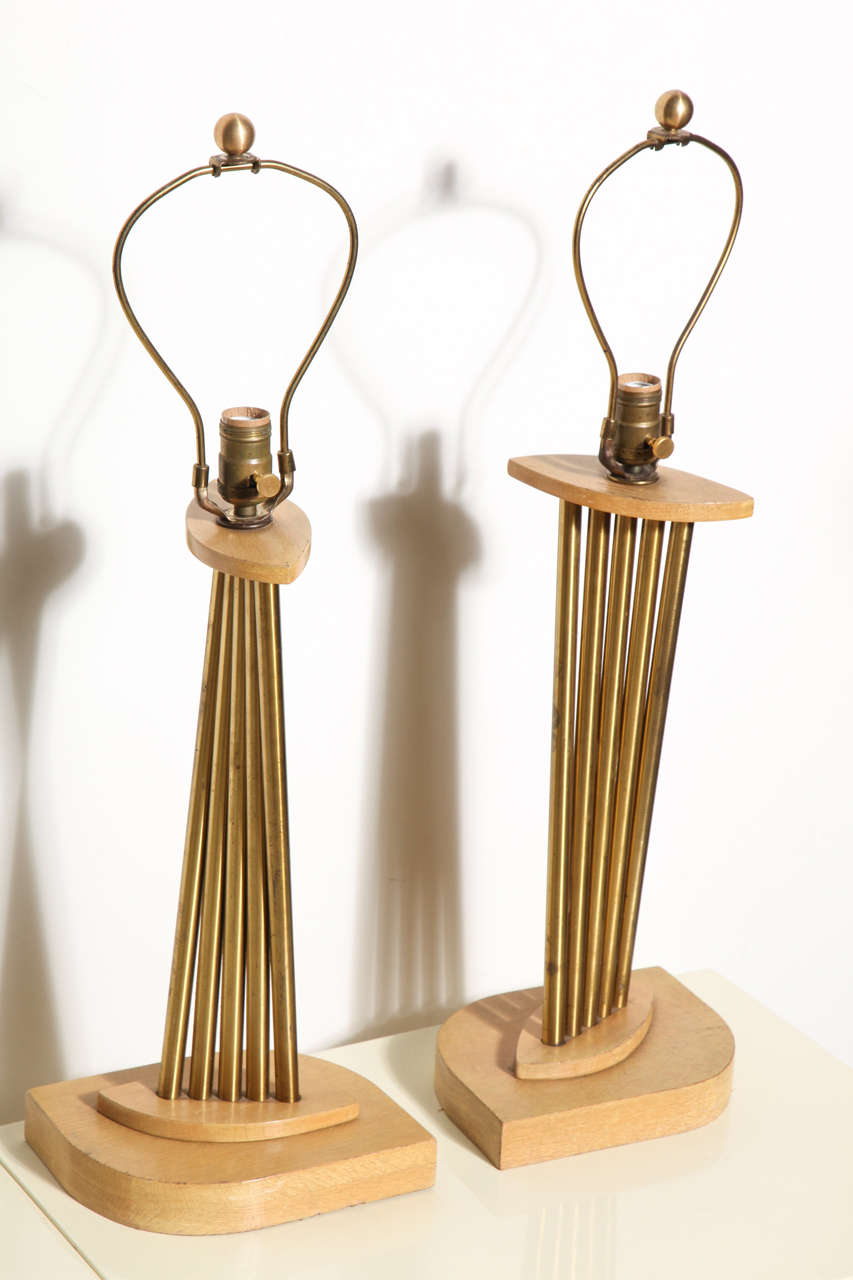 Architectural pair Russel Wright style brass and cerused oak table lamps. Featuring a curved accordion design with five cylindrical brass stems, elliptical bleached oak top and bottom on a leaf shaped 1.5 H base. WIth original harps. 20 H to top of