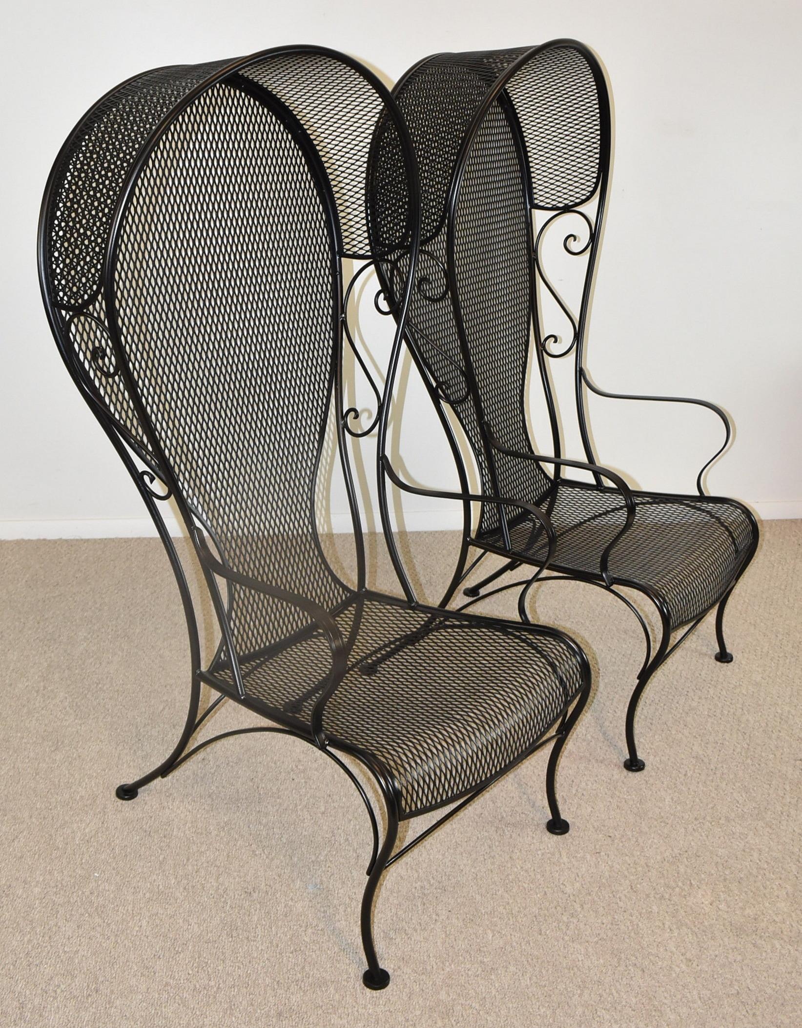Pair of Russell woodard high back princess canopy lounge chairs. Circa 1950-1959. Wrought iron high back canopy patio lounge chairs with corseted backs, also know as the Princess chair. Finished in black low Lustre paint and steel mesh. Indoor or