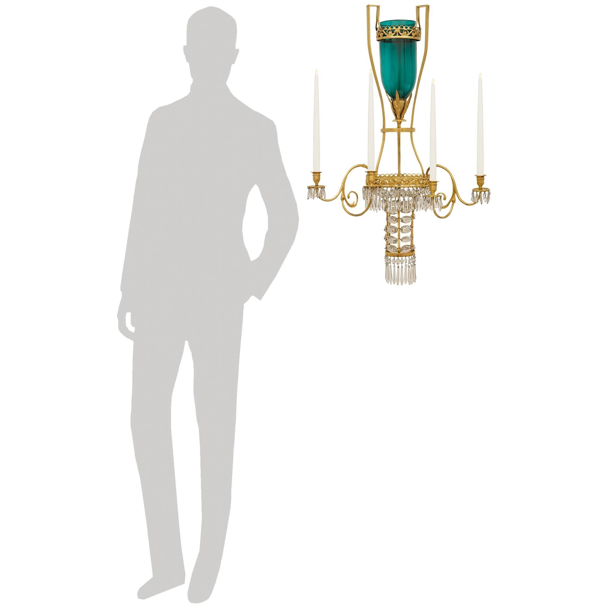 An exquisite pair of Russian 18th century Neo-Classical Period Ormolu and Crystal sconces. This exceptional and extremely decorative pair of sconces displays a 'D' shaped center with a pierced foliate scrolled band. The band supports the four double