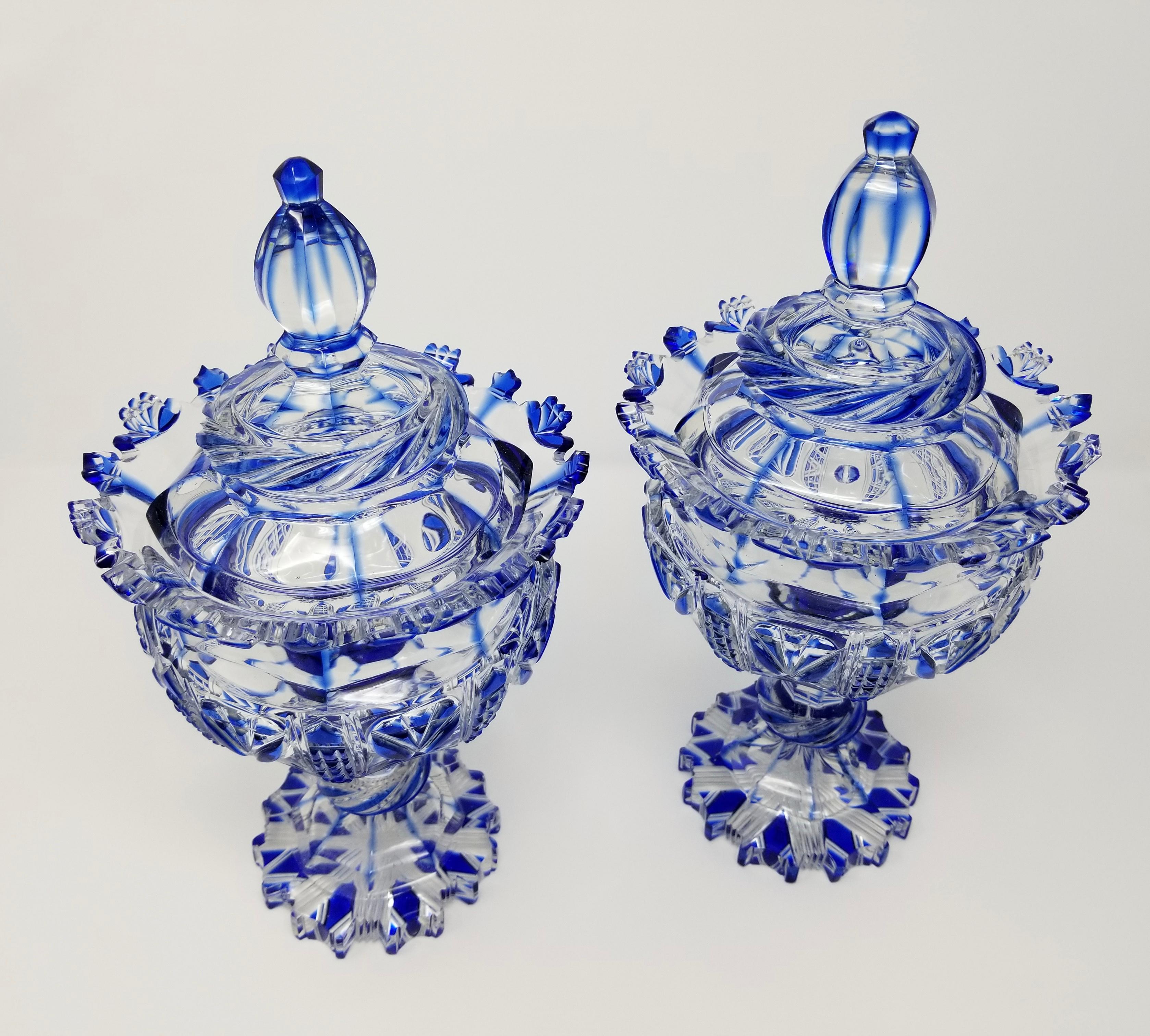 A Beautiful pair of 19th century Louis XVI style Russian cobalt blue hand-diamond cut to clear crystal covered urns/vases, attributed to Imperial Russian glass manufacturing. Each urn is beautifully hand-diamond cut with two layers of crystal, which