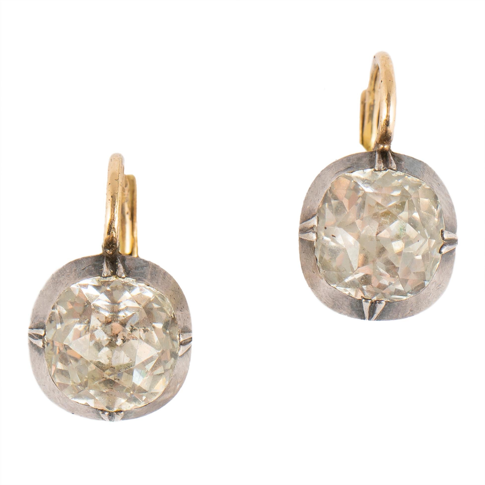 From the Romanov era, period of Tsar Nicholas II, these lovely earrings are drop shaped and bezel set with a cushion-shaped paste simulating an old diamond, mounted in silver and gold. Made in the Imperial capital of Russia before the 1917