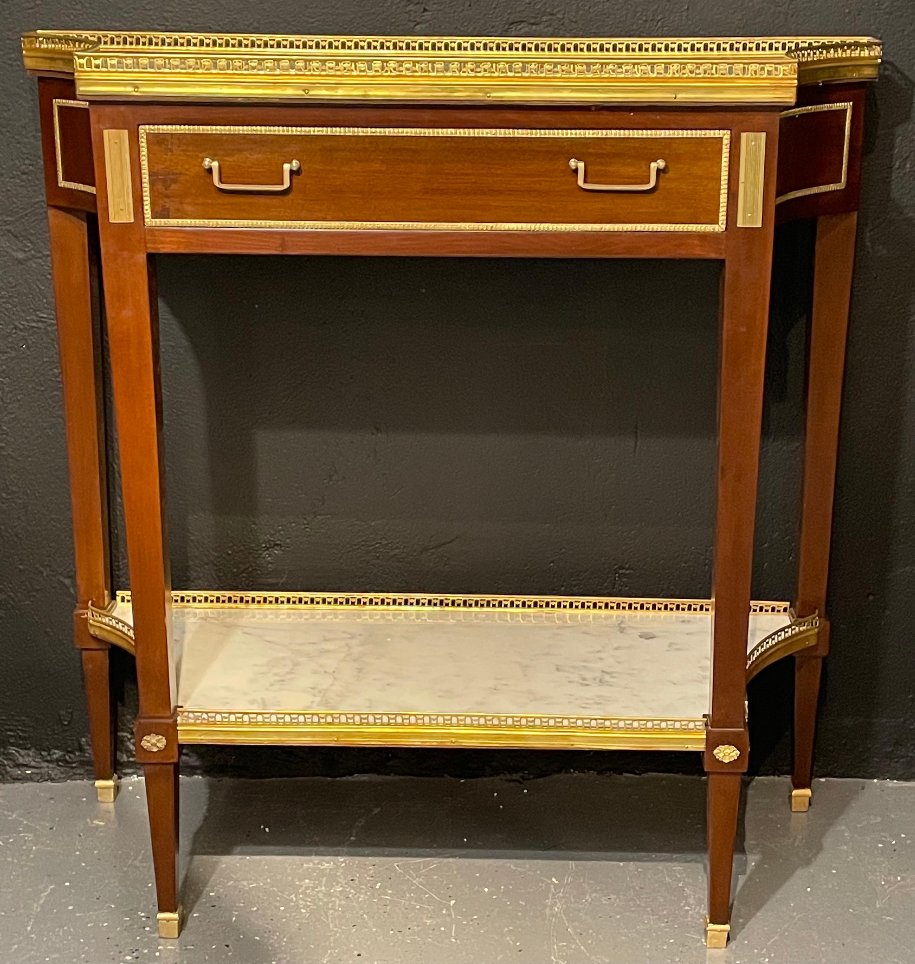 A pair of Russian style console tables having the Maison Jansen look and flair for design. This finely crafted and design pair of console, serving or sofa tables have inverted sides sporting a pierced bronze gallery framing a white and gray veined