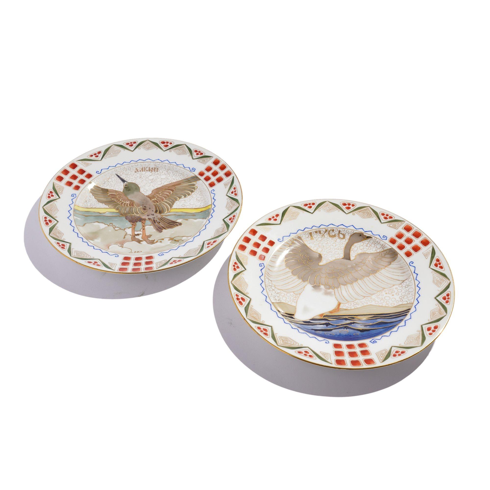 Pair of Russian porcelain dinner plates with native Russian ornithological specimens. The center of the plates are painted with a stylized kingfisher in a landscape and a wild goose in a seascape after designs by Ivan Galnbek (1855-1934). The rims