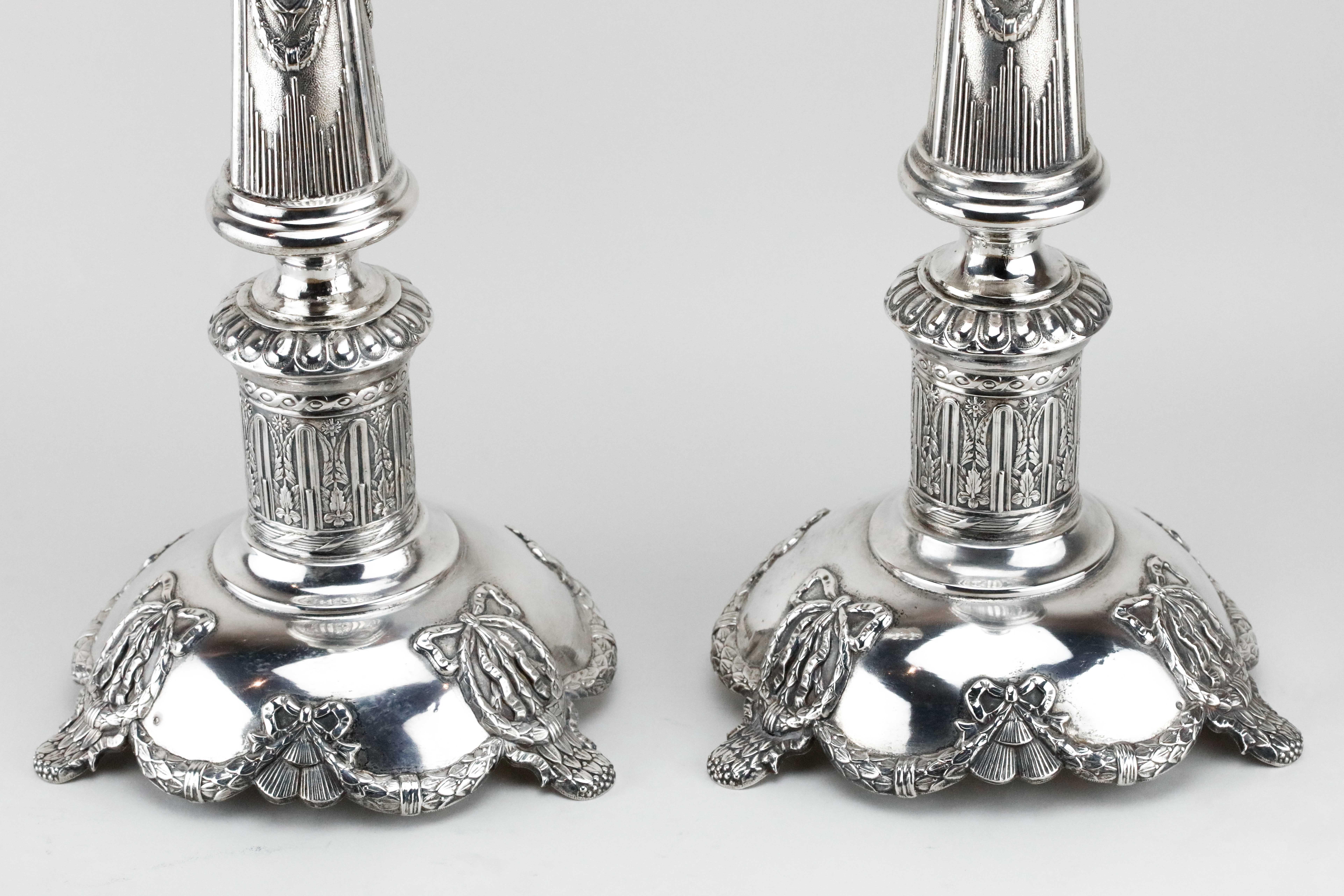 Large neoclassical silver Shabbat candlesticks, Isaac Szekman, Poland, circa 1880.
Beautifully chased with various ribbon and leaves ornaments in typical neoclassical design. Set on a wide, chased base.

Marked on the base with 