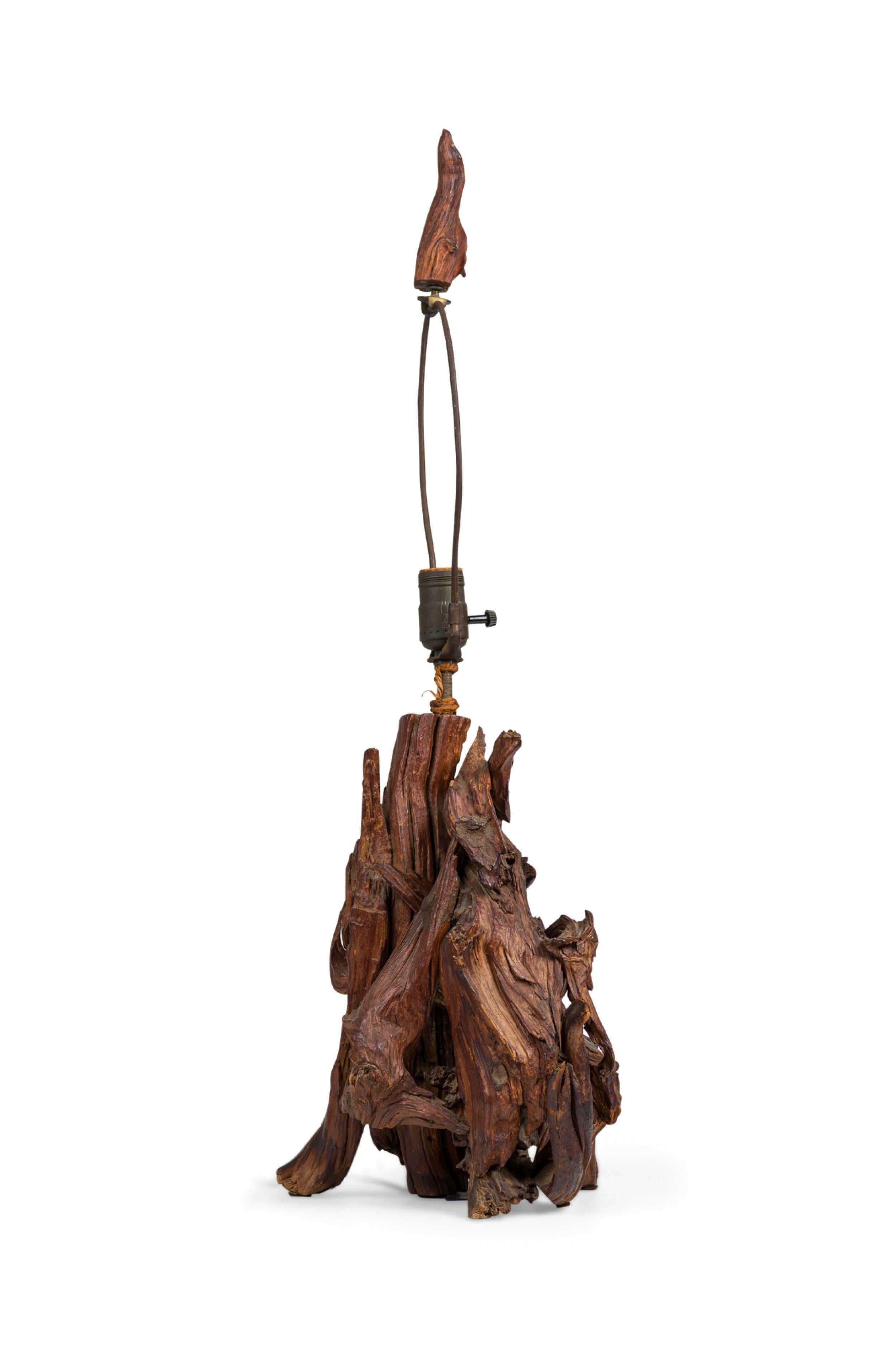 PAIR of Rustic Adirondack organic driftwood table lamps with similar openwork bodies composed of intertwined branches with ascending trunk stems, embedded functioning brass light switch sockets with harps, topped by driftwood finials. (PRICED AS