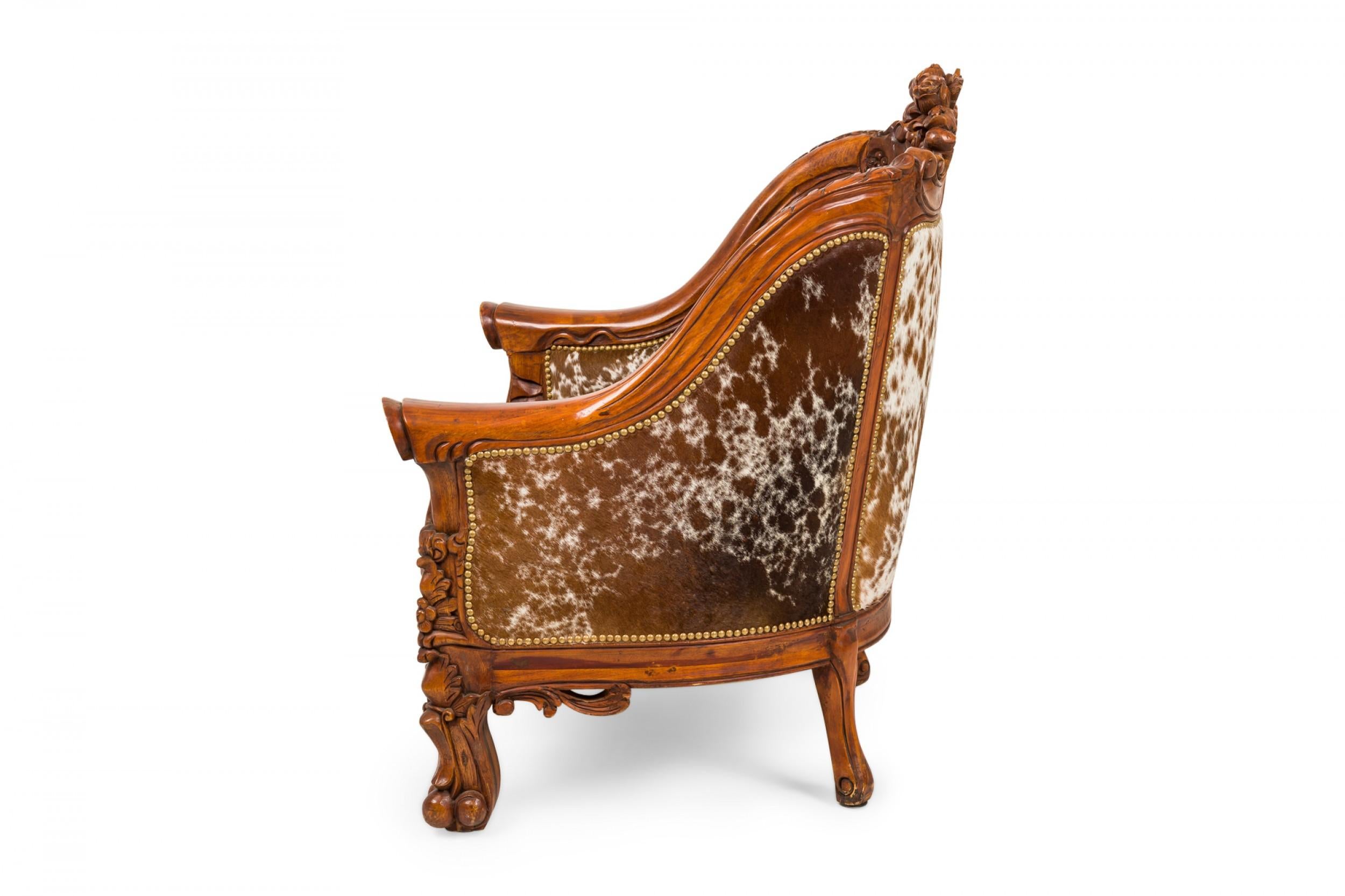 20th Century Pair of Rustic American Carved Walnut and Cowhide Wide Lounge / Armchairs For Sale