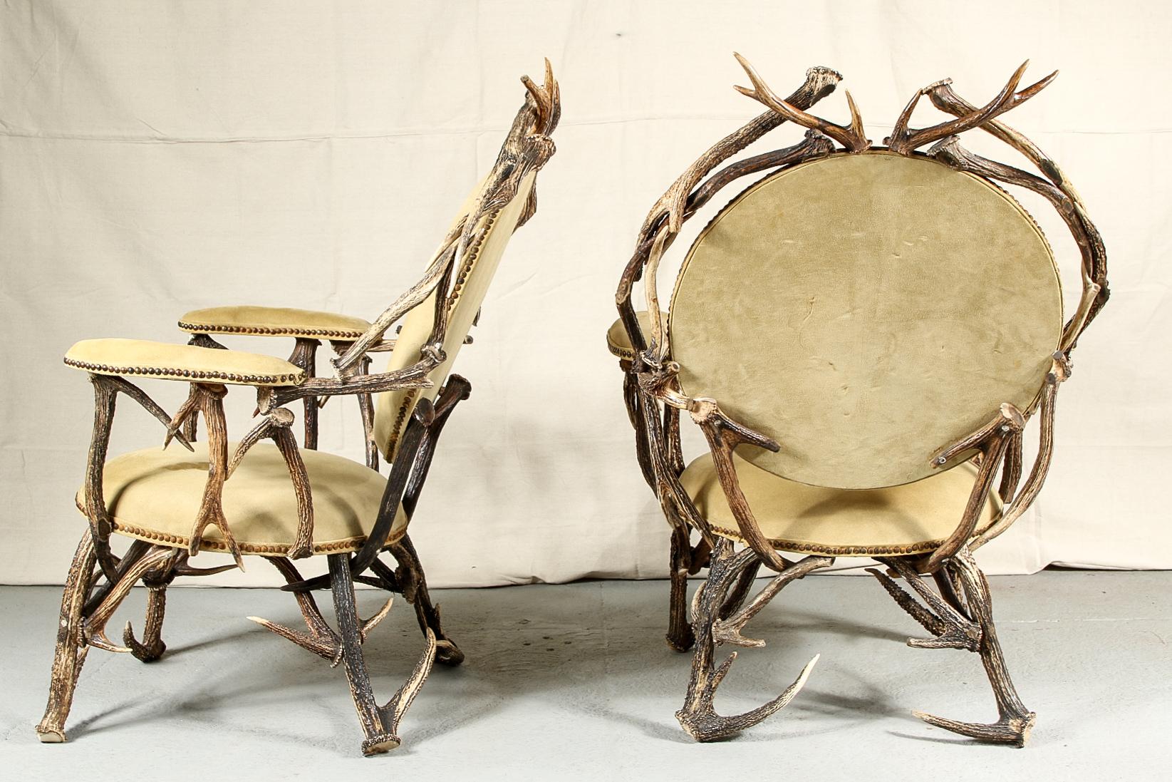 Rustic antler armchairs, elaborate antler construction with tan suede round seats and backs and curved arms with nail head trim.

Condition: Expected wear and signs of use including some staining to seats.