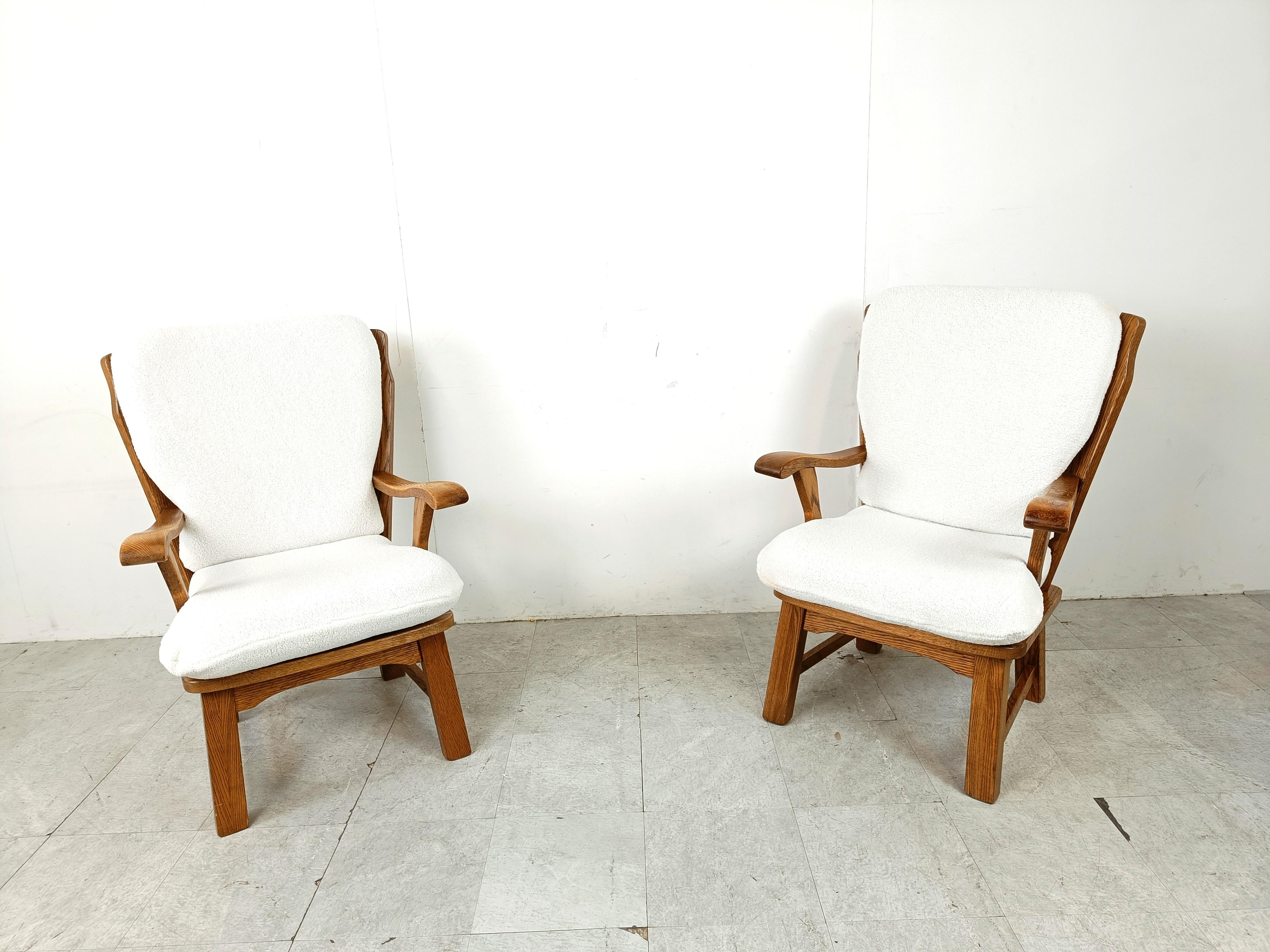 Pair of rustic solid oak armchairs with comfortable and fresh looking reupholstered boucla cushions.

These elegantly shaped wooden chairs add a rustic touch to your interior.

1950s - France

Very good condition

Height: 100cm
Width: 66cm
Depth: