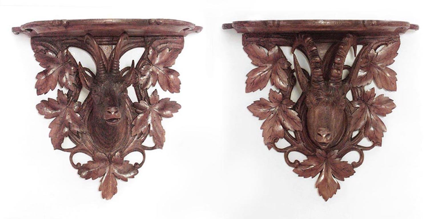 Pair of Rustic Black Forest (19th Cent) walnut wall shelves with one mountain goat and one pronghorn with leaf carved design
