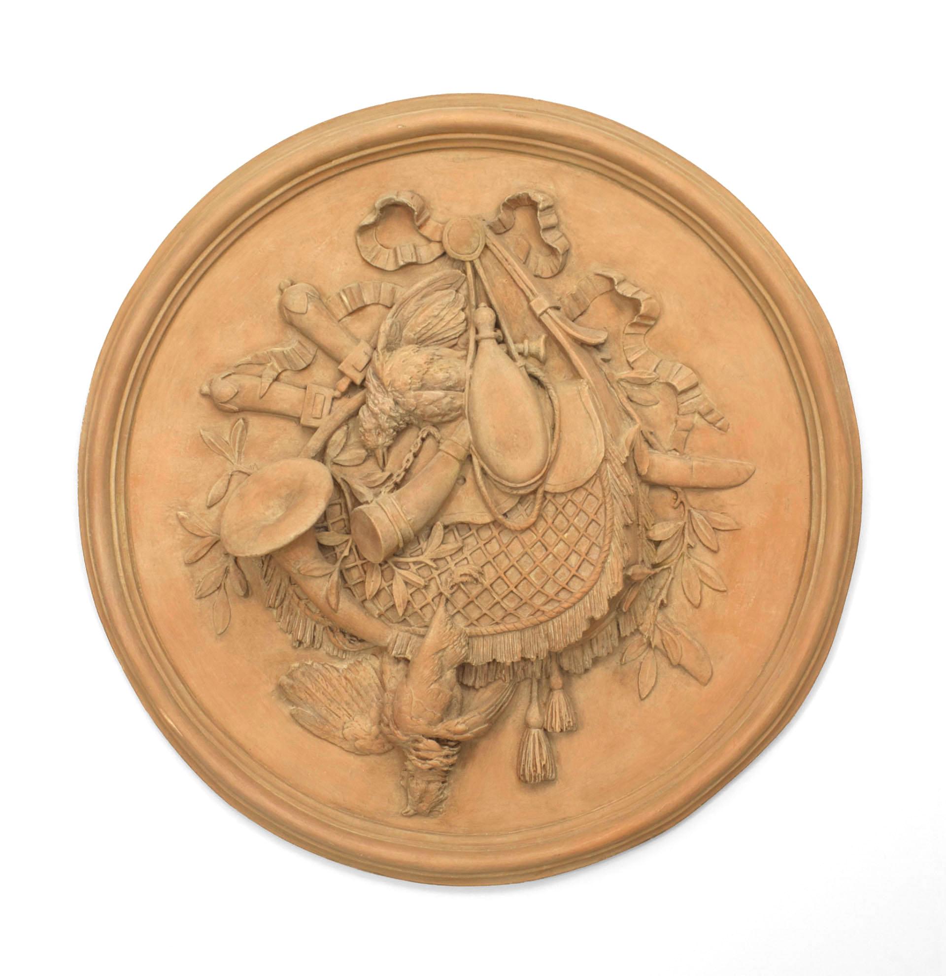 Pair of Rustic French style resin (faux terra cotta) bleached round wall plaque medallions with game and trophy motifs and a bow-knot top (PRICED AS Pair).
