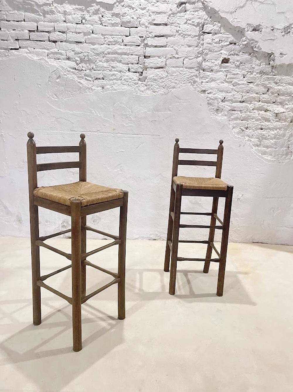 This charming pair of rustic bar stools originates from the Mediterranean region — most likely Spain or Italy — and dates back to the mid-20th century. Featuring a simple ladder-back design and hand-woven natural rush seats, these stools represent