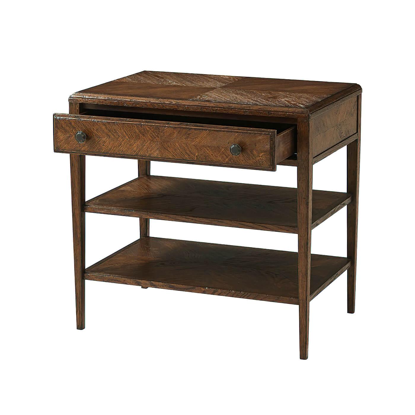 A rustic-style nightstand with an oak parquetry top that is mirrored on the two shelves below. It has one frieze drawer with a mirrored herringbone pattern and Fine Verde Bronze handles.
Shown in dusk finish
Dimensions: 29