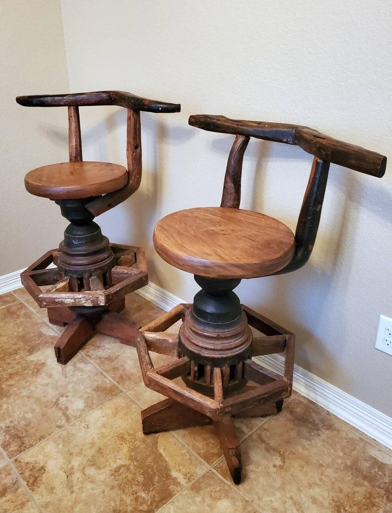 An incredible pair of rustic, Adirondack style / Western style bar stools / pub counter chairs with outstanding patina. 

Hand-crafted, fashioned from reclaimed timber and antique elements, featuring highly desirable planed teak bark wood, an