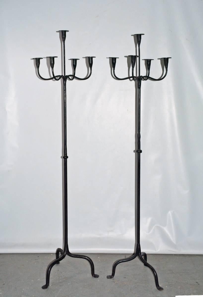Each of the contemporary wrought iron candleholder floor torchieres are handcrafted and hold five candles. The bases have three splayed legs. Two candle stands are of slightly different height.

Measures: Right candle stand - D 14.50