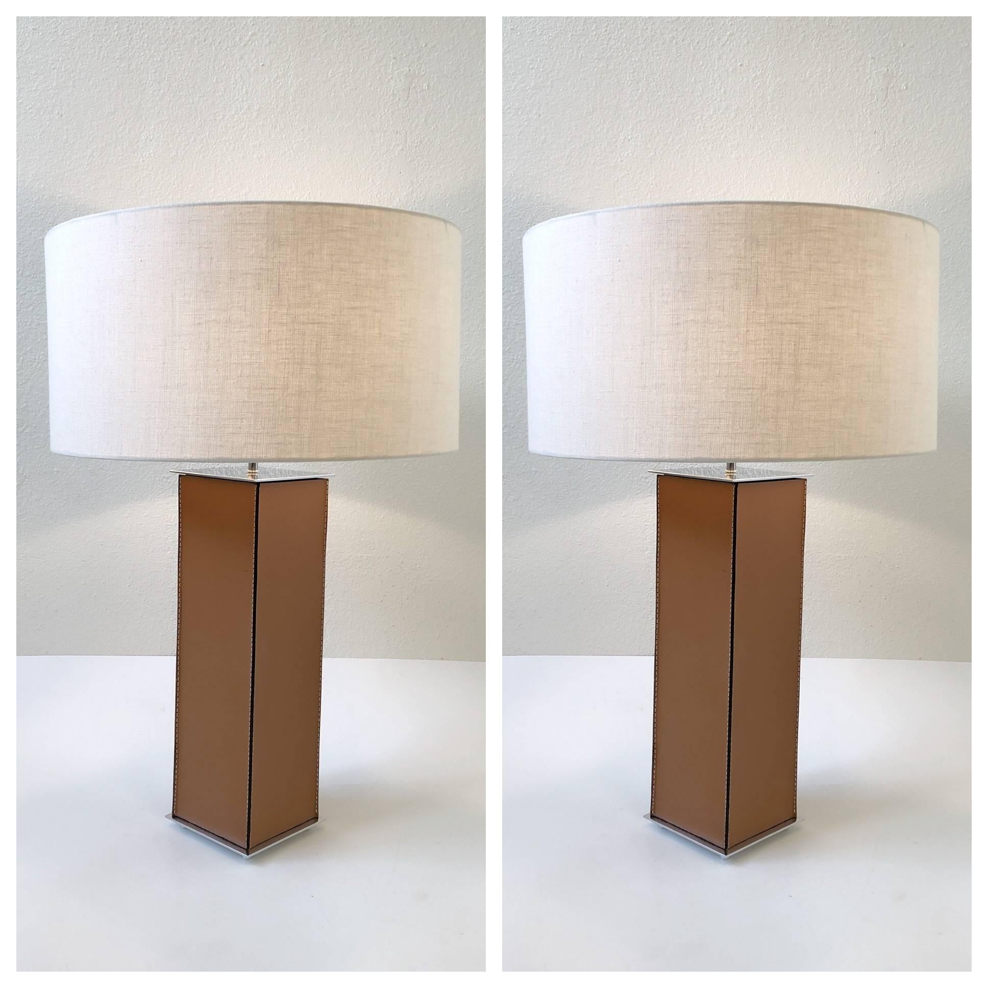 A glamorous pair of saddle stitch leather table lamps from the 1970s by Laurel Lamps.
The lamps have been newly rewired and new linen shades.

Dimensions: 30.5” high, 20” diameter.
Base is 6” by 6”.