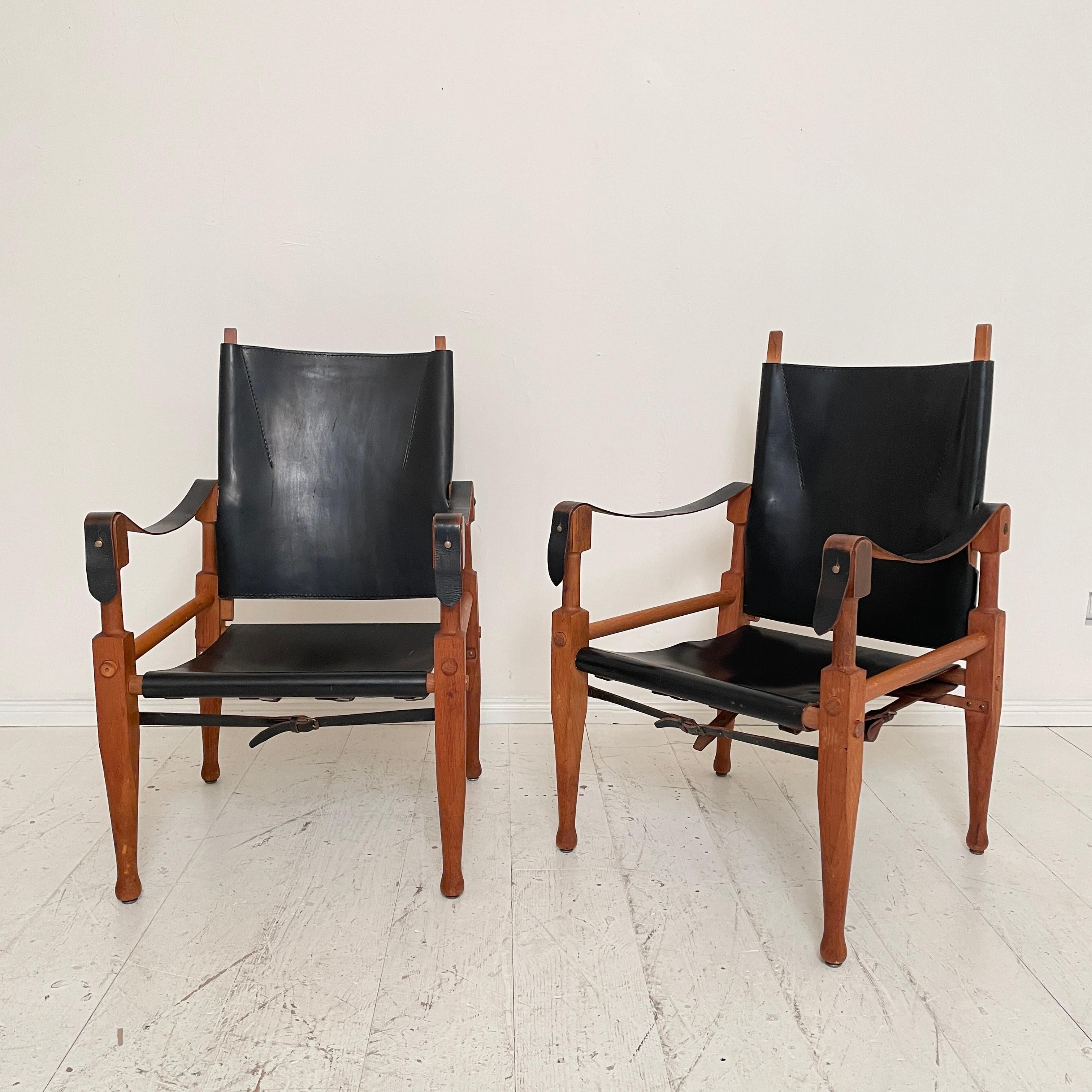 This beautiful pair of mid-century Safari armchairs by Wilhelm Kienzle for Wohnbedarf from the 1950s are made of black leather and oak. 
They are in great original condition.
A unique piece which is a great eye-catcher for your antique, modern,