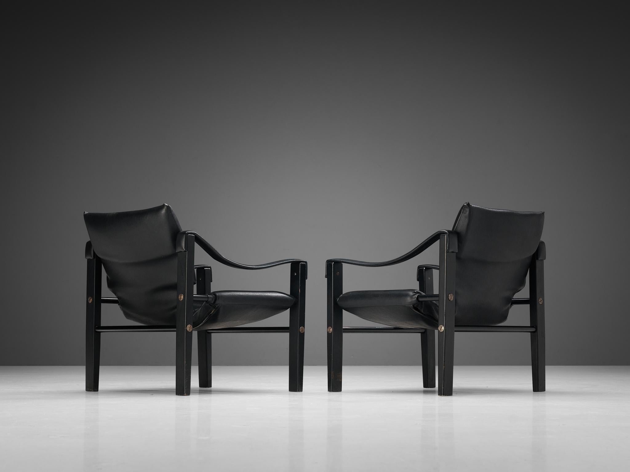 Pair of 'Safari' lounge chairs, vinyl, lacquered wood, metal, United Kingdom, circa. 1965

These well-constructed armchairs have a solid appearance. The frame is made up of four cube-shaped legs and tubular cross connections. As characteristic for