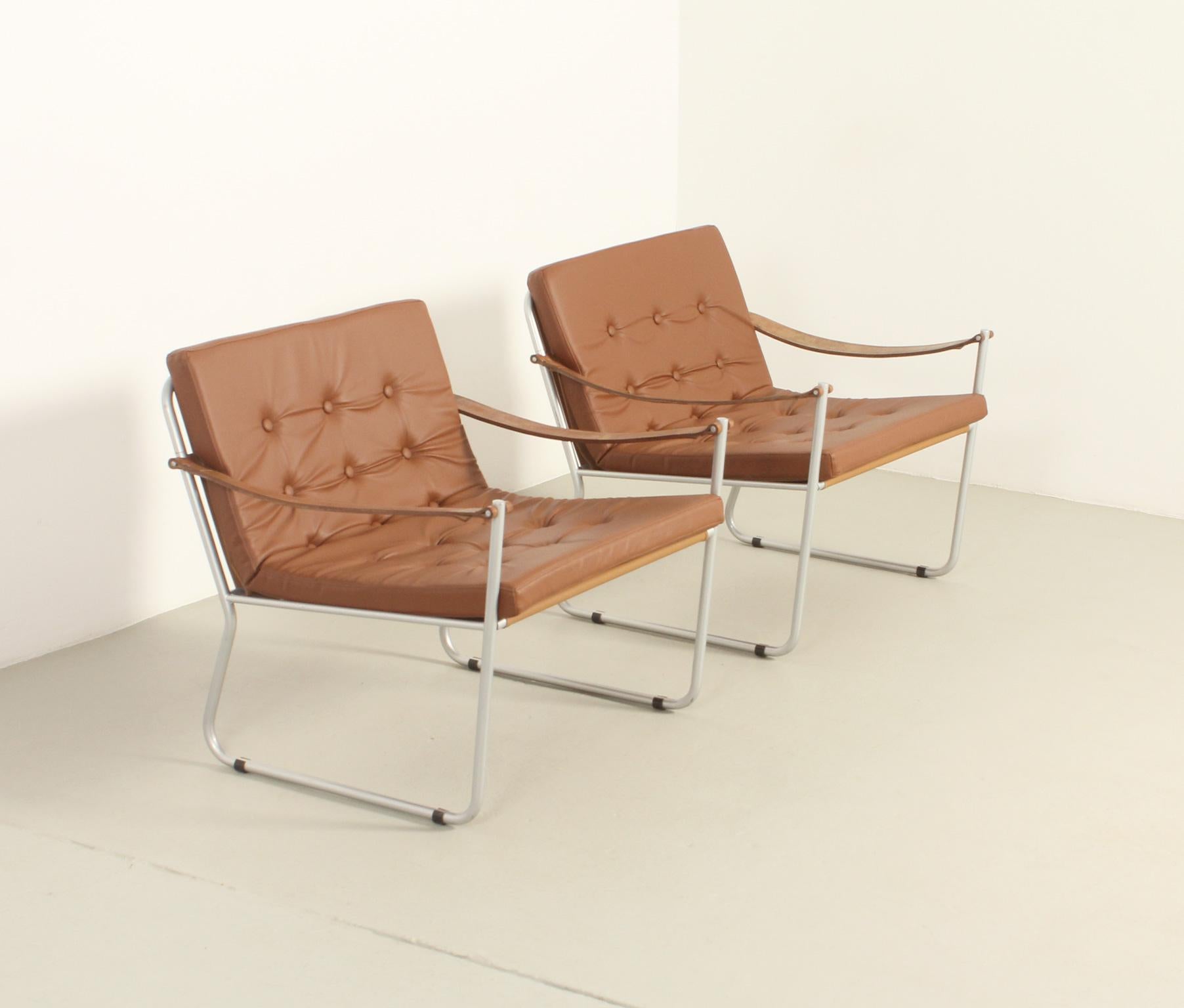 Paire de fauteuils de style safari avec accoudoirs en cuir, années 1960. Structure en métal avec harnais et coussin en vinyle et accoudoirs en cuir d'origine.